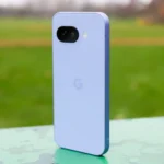 Điện thoại Google Pixel 9a màu tím đứng ở công viên, cho thấy mặt lưng.