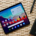 Điện thoại Google Pixel Fold đặt trên bàn mây cùng sổ ghi chép
