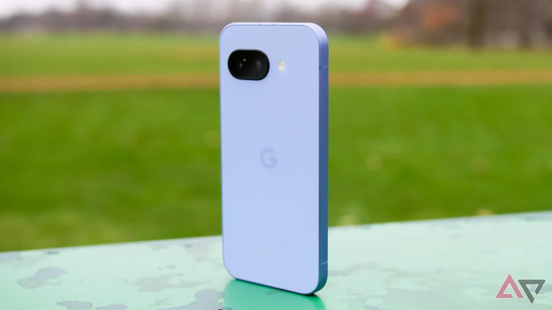 Google Pixel 9a màu Tím đứng ở công viên, hiển thị mặt lưng