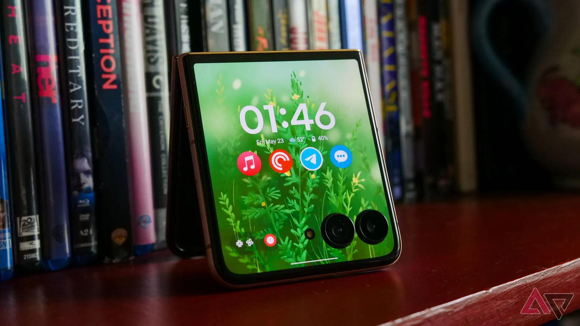 Motorola Razr Ultra 2025 với màn hình ngoài hiển thị, đặt trên giá sách gỗ