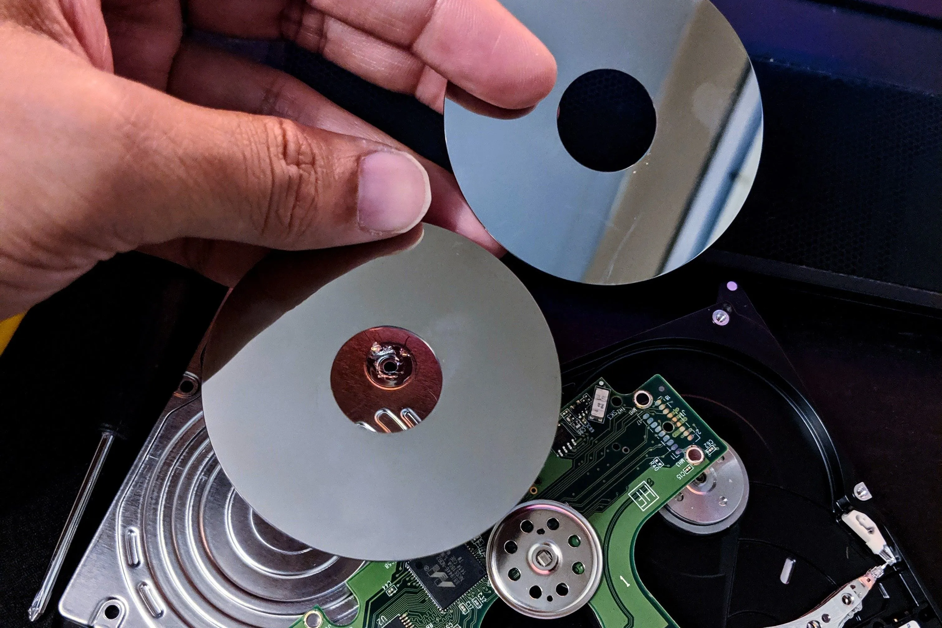 Các phiến đĩa bên trong ổ cứng HDD vật lý, đại diện cho tính cố định của việc phân vùng ổ đĩa
