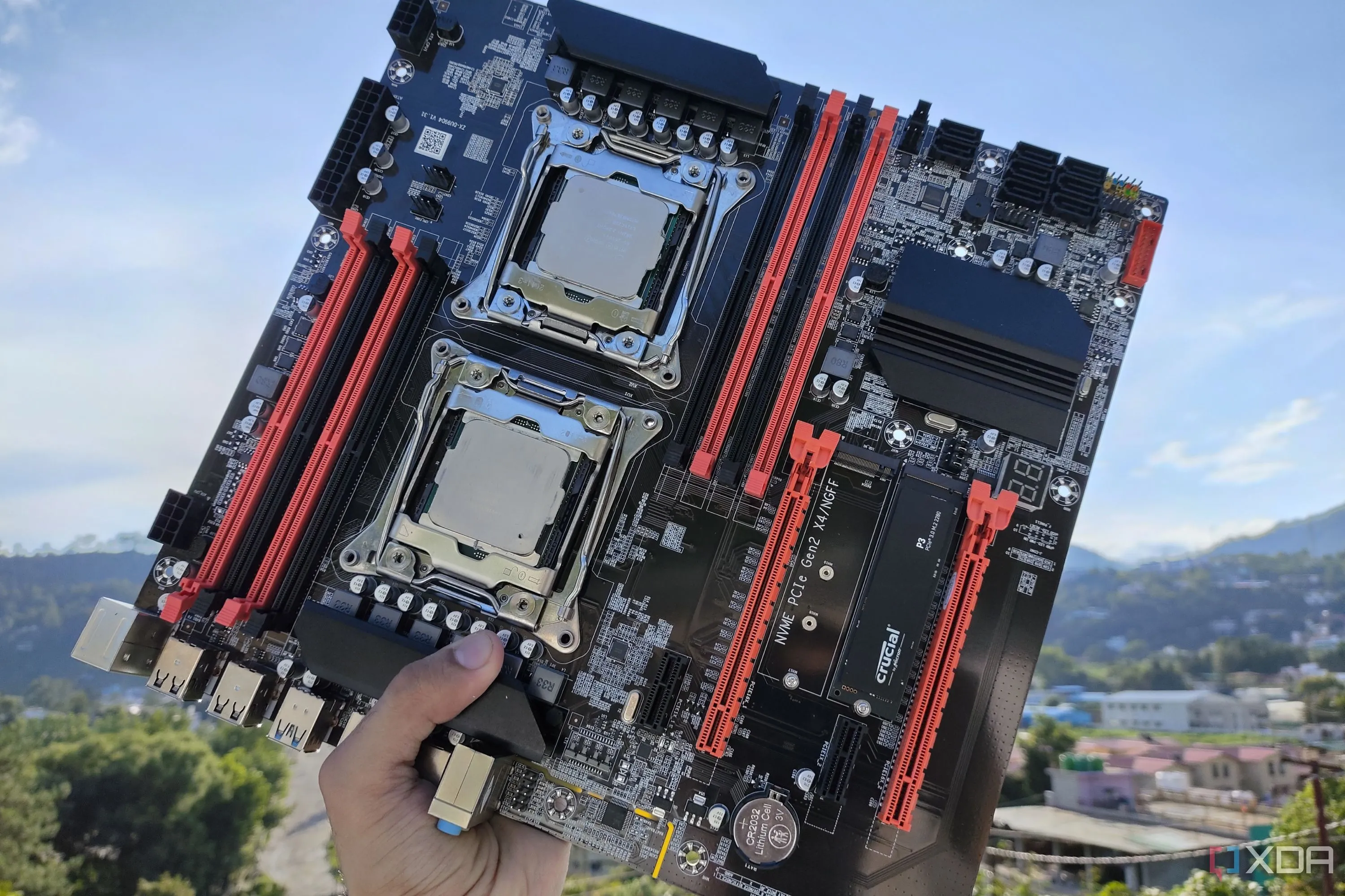 Người dùng đang cầm bo mạch chủ server X99 với hai CPU Intel Xeon, nhấn mạnh khu vực VRM và chipset