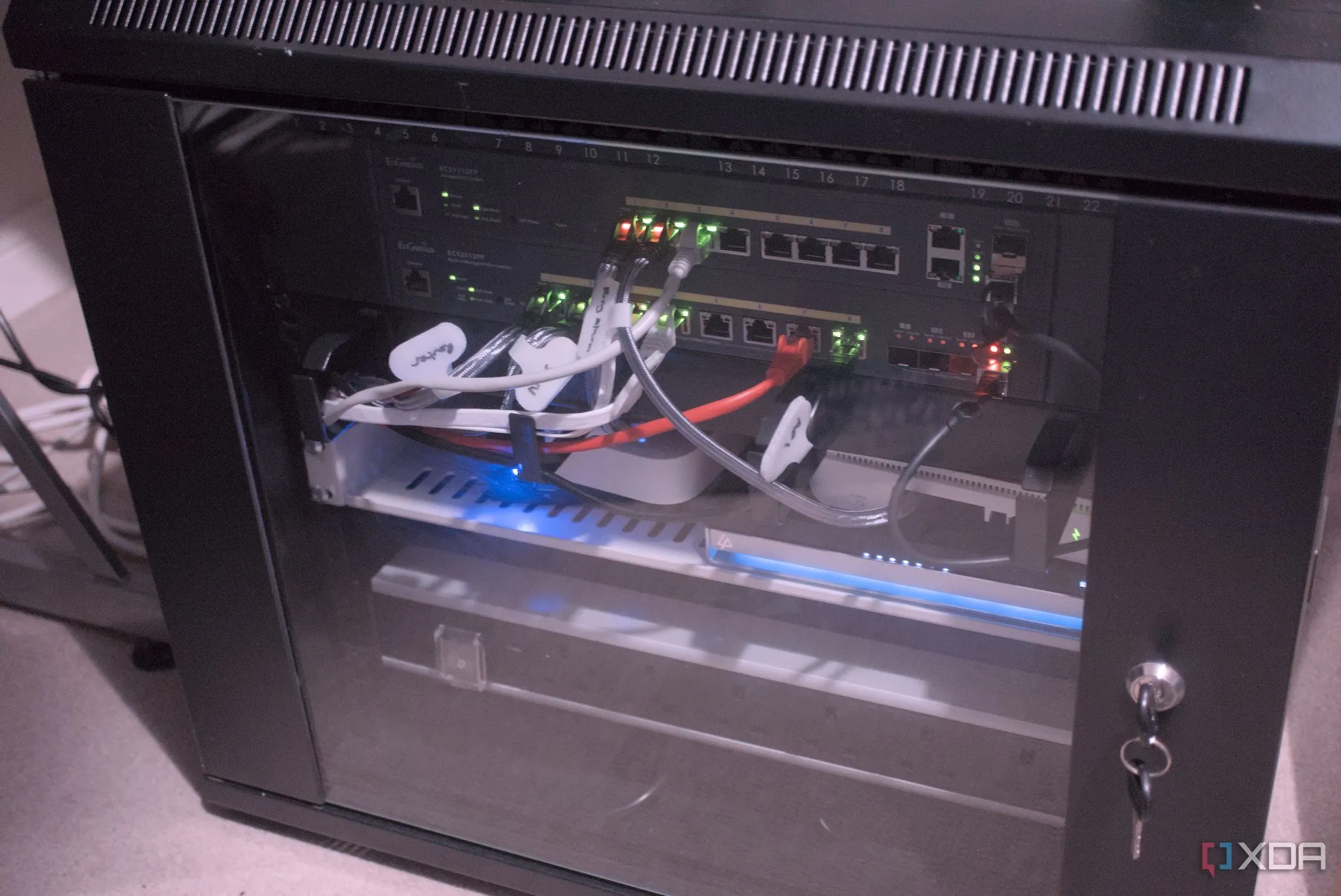 Tủ mạng chứa các thiết bị mạng và máy chủ, tượng trưng cho hạ tầng của một Home Lab và nhu cầu giám sát liên tục.
