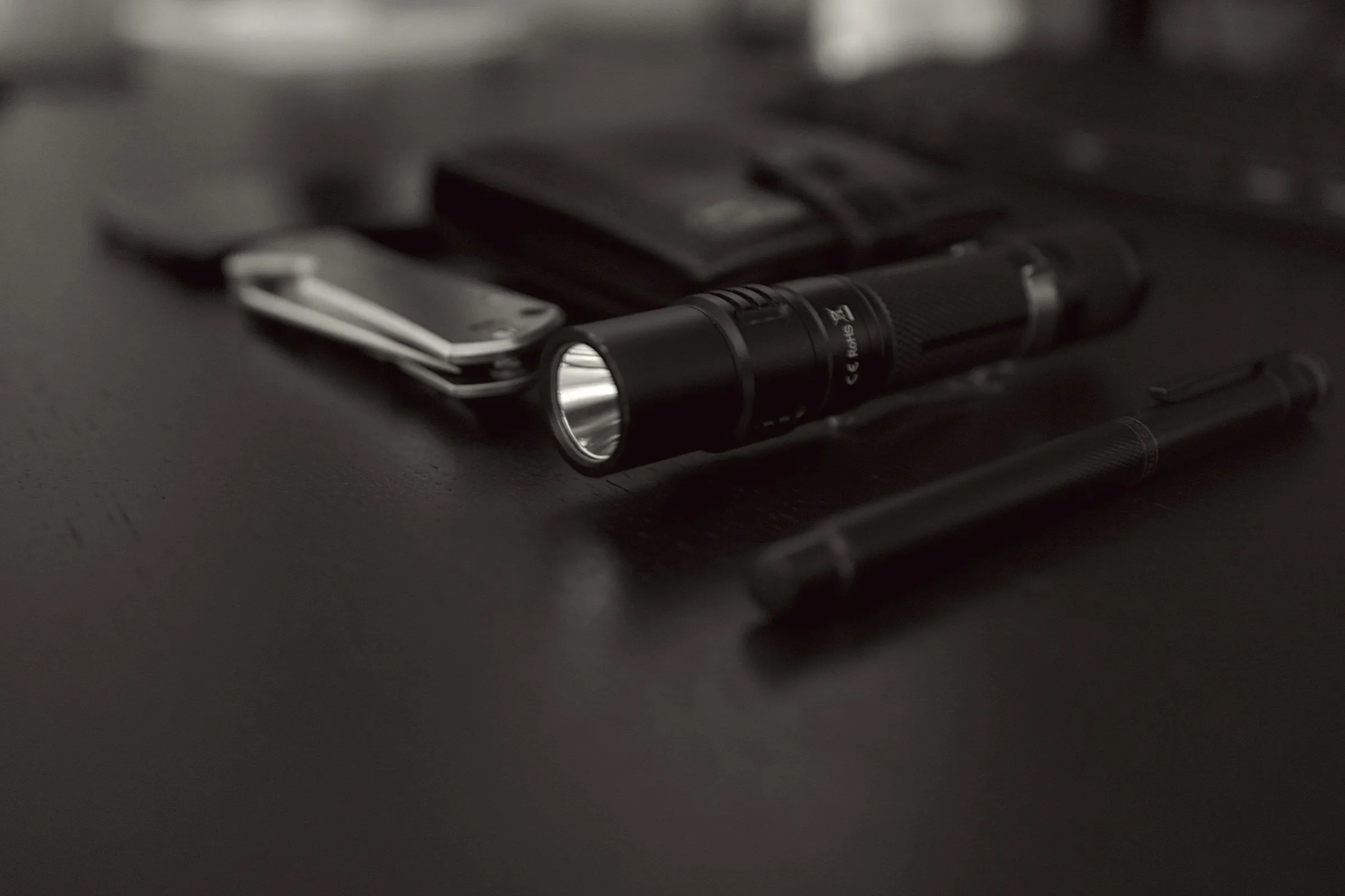 A small black flashlight on a desk
