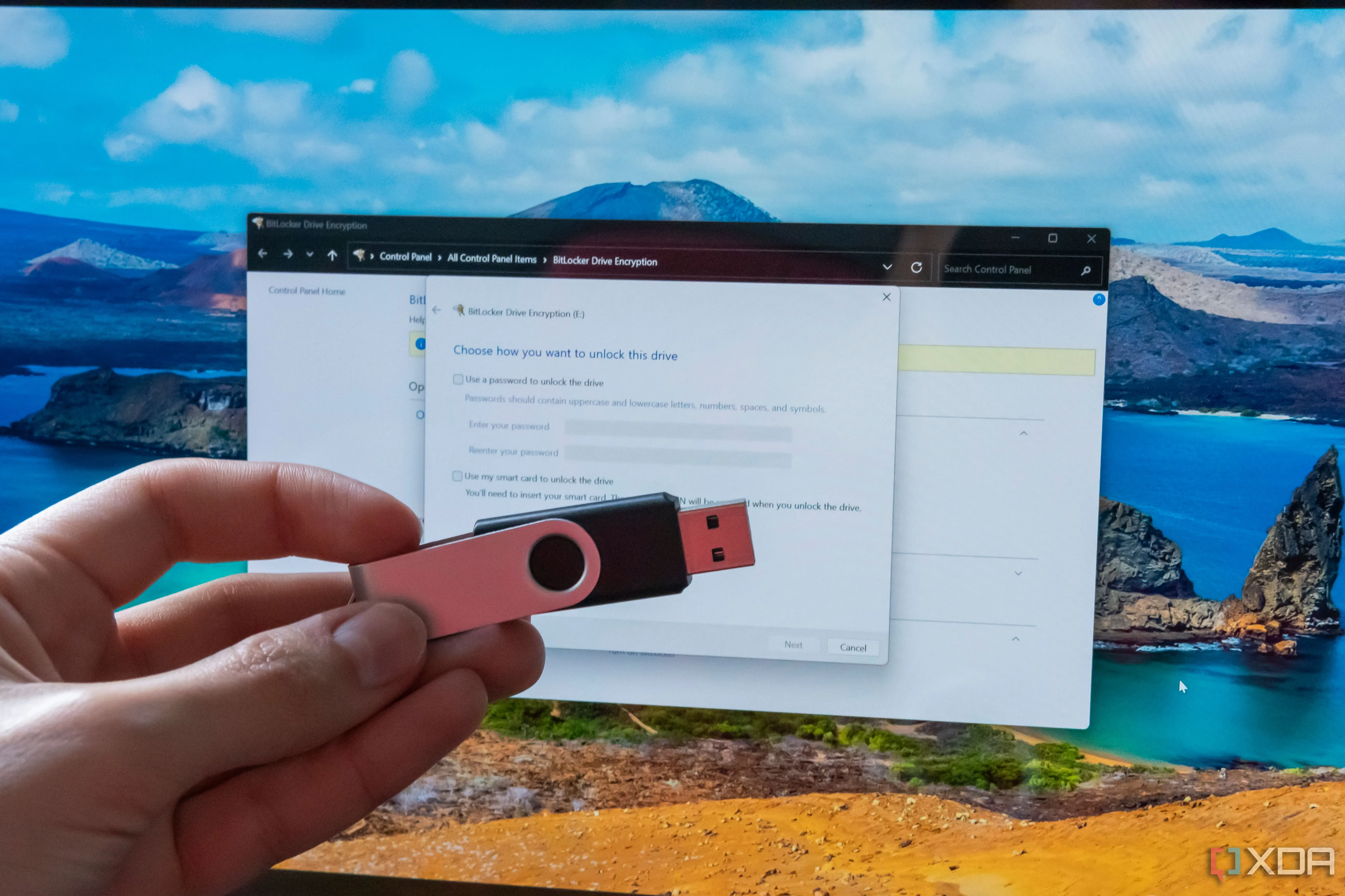 Bàn tay cầm USB trước màn hình hiển thị cài đặt BitLocker, minh họa các giải pháp khóa bảo mật
