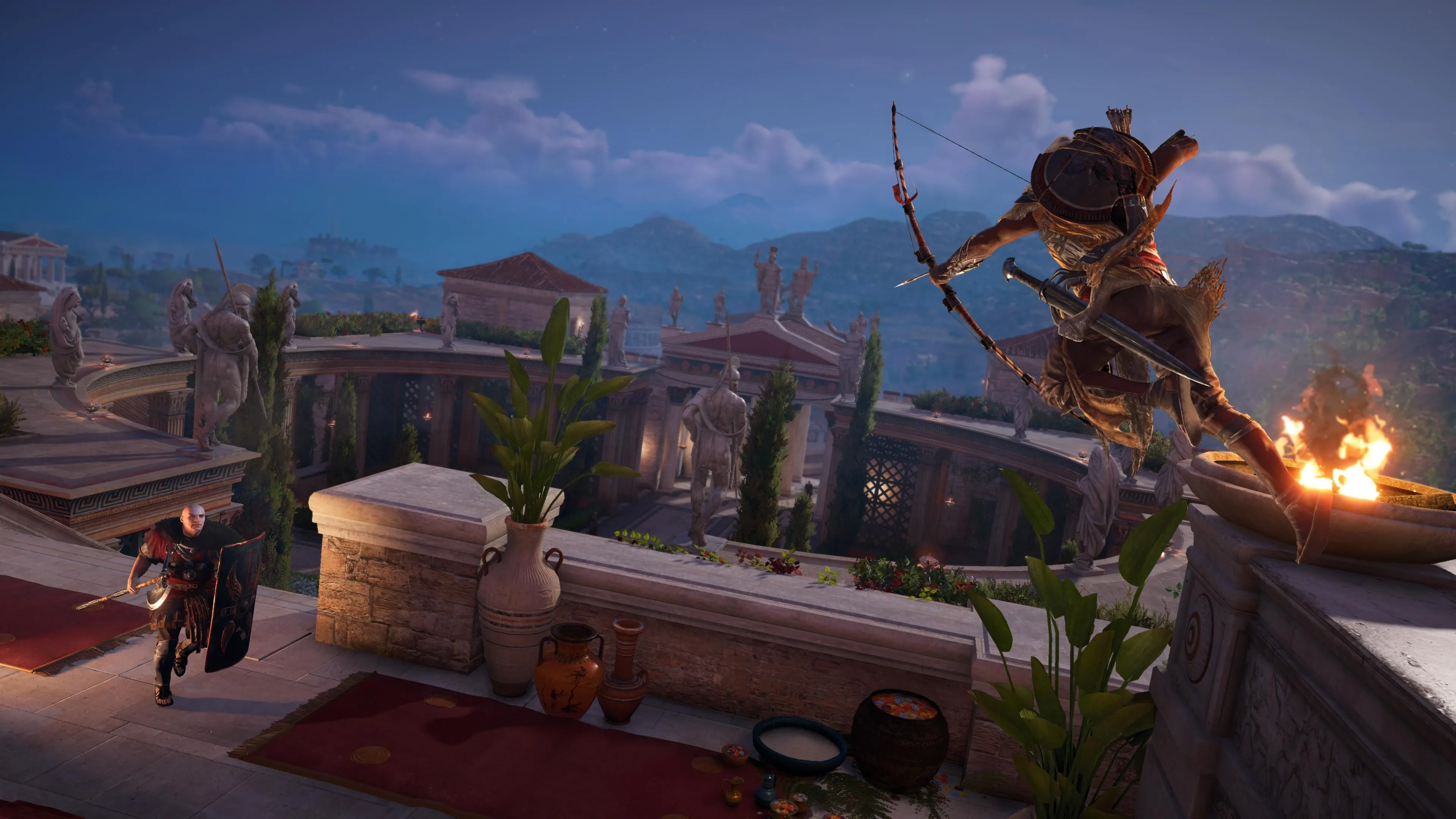 Bayek nhảy từ vách đá và nhắm cung vào một người lính cầm khiên trong Assassin's Creed Origins