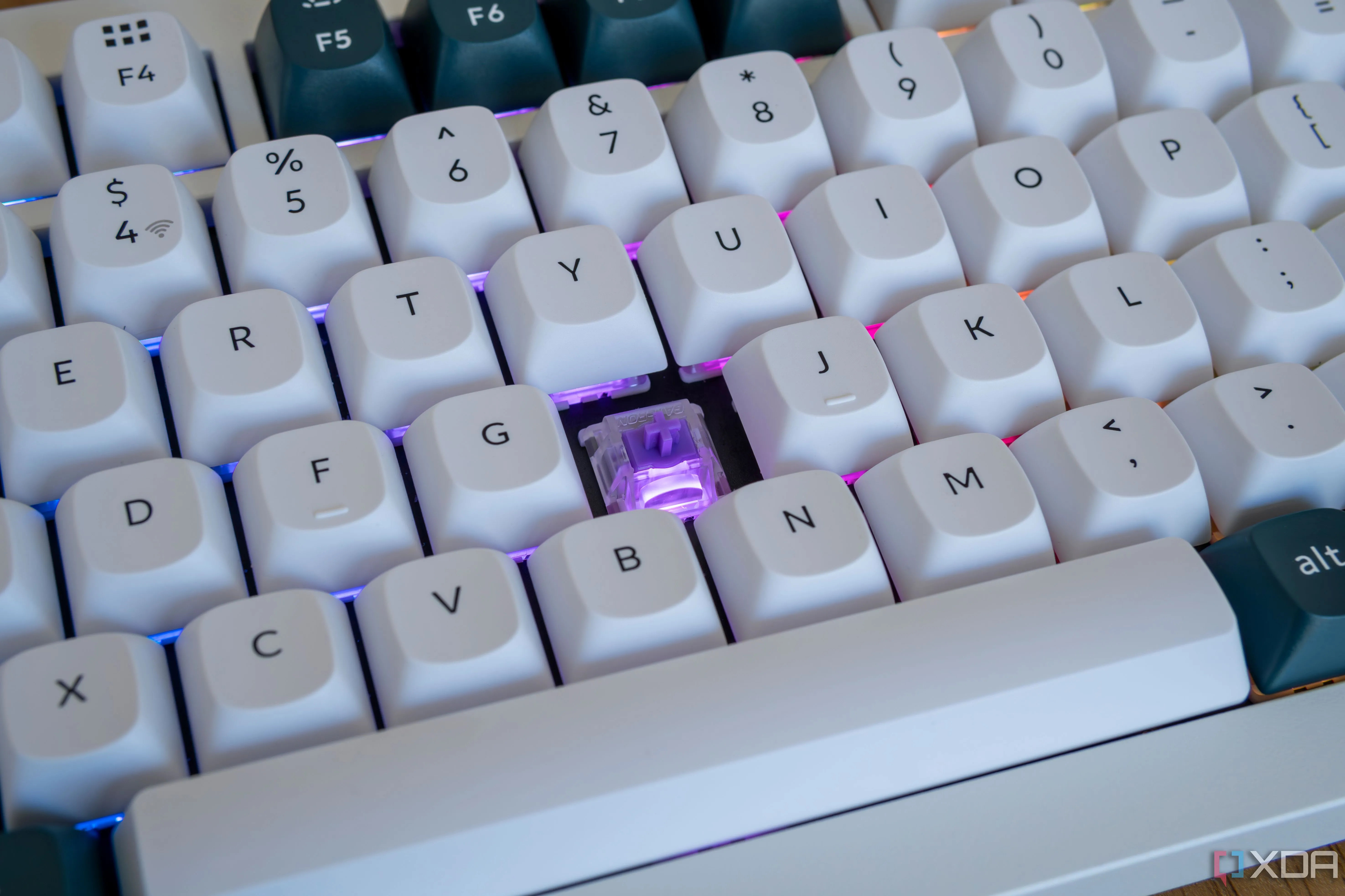 Cận cảnh Keychron Q1 HE với một phím keycap được tháo ra và ánh sáng tím từ switch