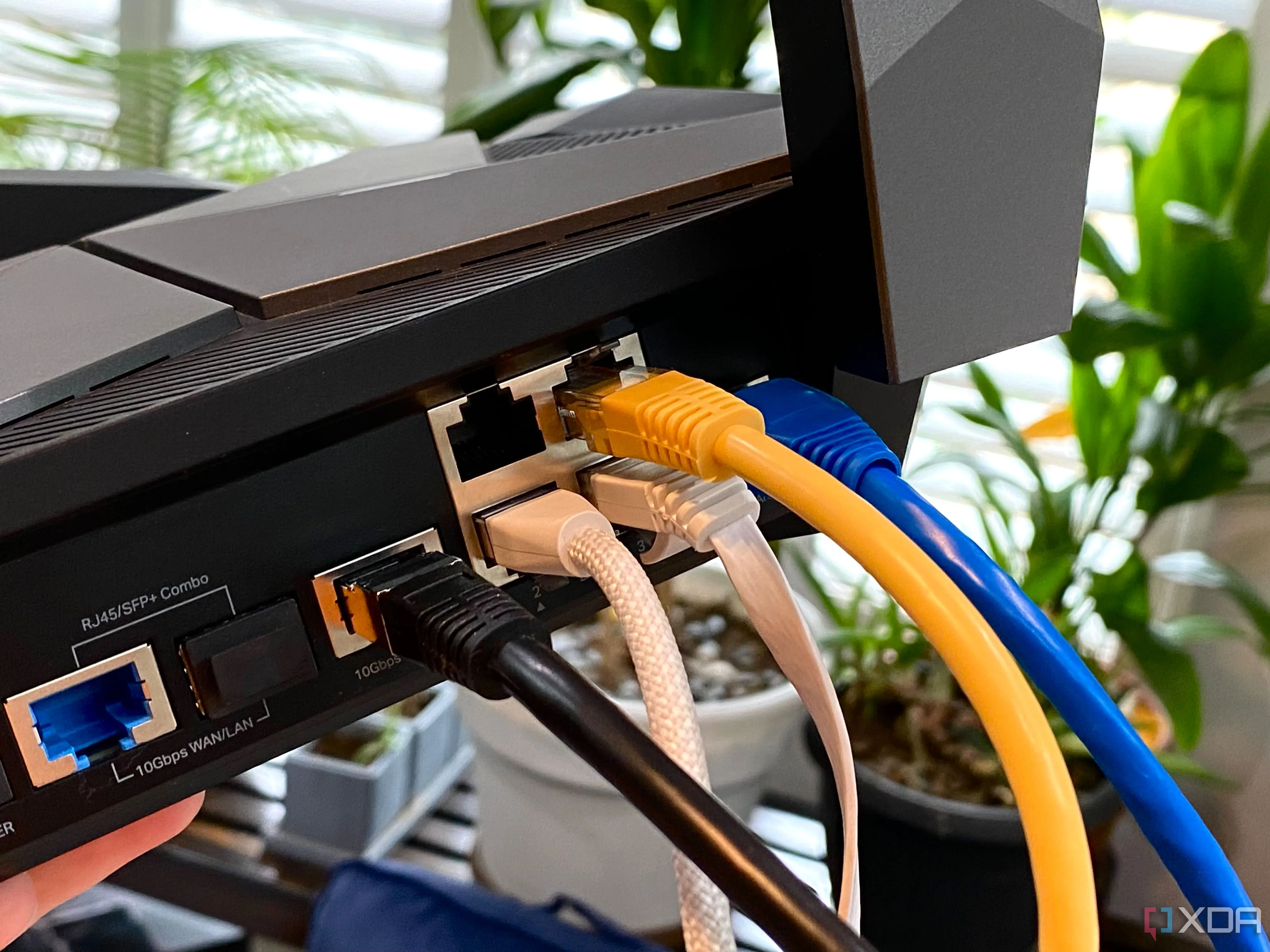 Cáp Ethernet nhiều màu sắc cắm vào router TP-Link Archer AXE300, biểu tượng của một hệ thống mạng gia đình tự chủ và hiệu suất cao.