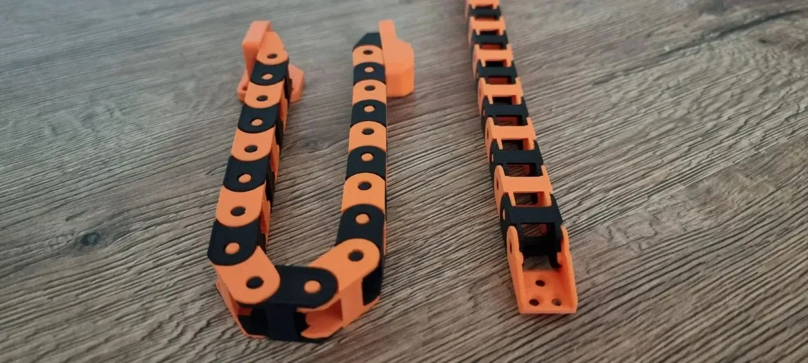 Dây xích cáp in 3D do Scops Owl Designs tạo ra, đang bảo vệ và định tuyến các dây điện chuyển động, một giải pháp linh hoạt cho máy in 3D và các thiết bị tự động.