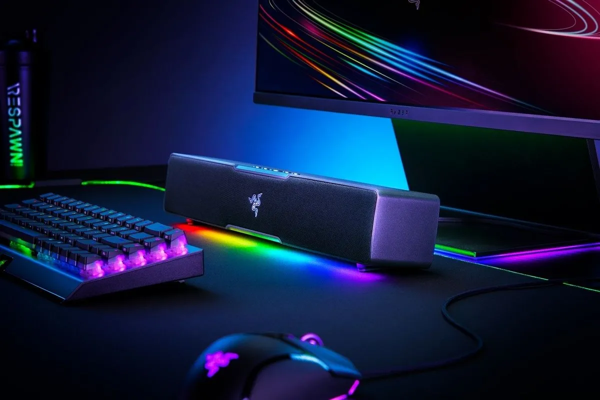 Góc nhìn cận cảnh soundbar Razer Leviathan V2 X có đèn RGB, đặt cùng bàn phím, chuột và màn hình trên bàn máy tính