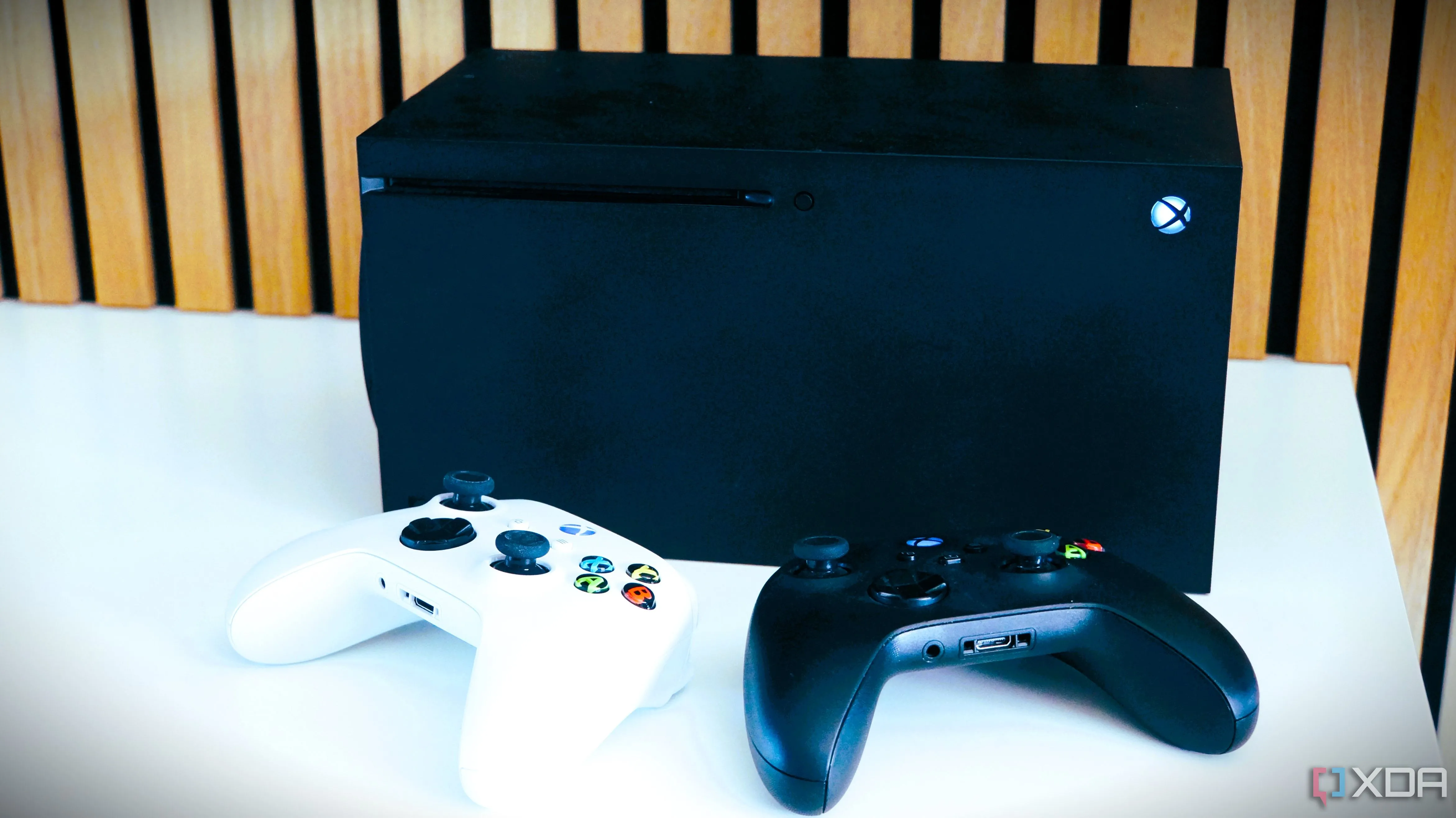 Hai bộ điều khiển Xbox đặt trước máy chơi game Xbox Series X minh họa việc tăng giá phần cứng và game console