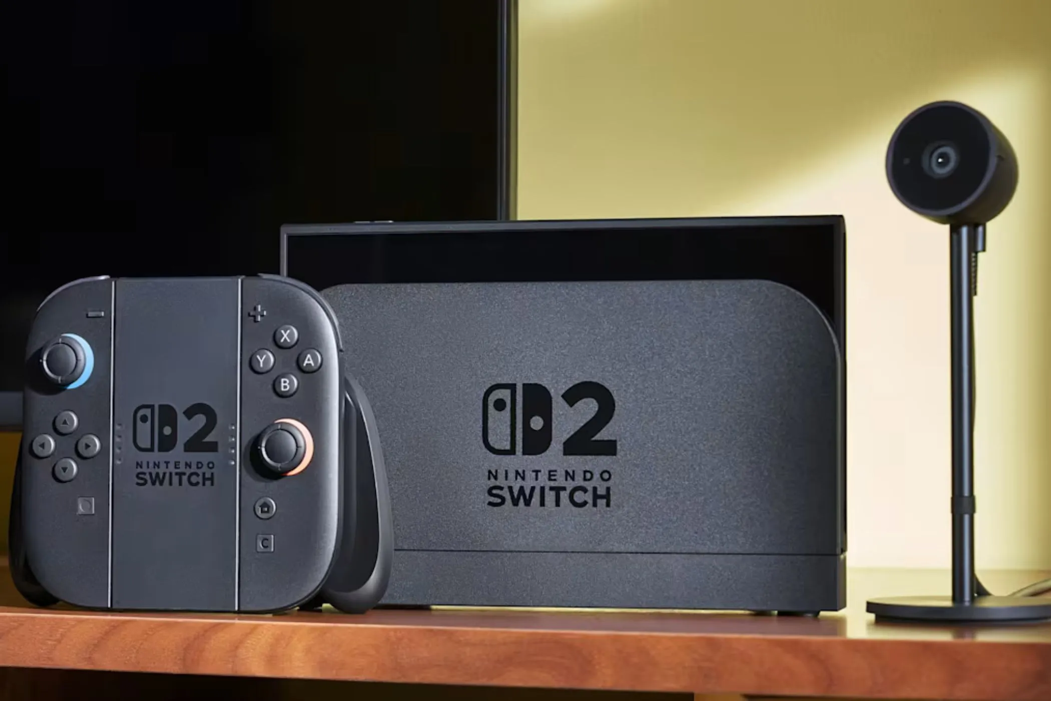Hệ thống console Nintendo Switch 2 màu trắng được đặt trên một chiếc bàn, bên cạnh là một máy ảnh