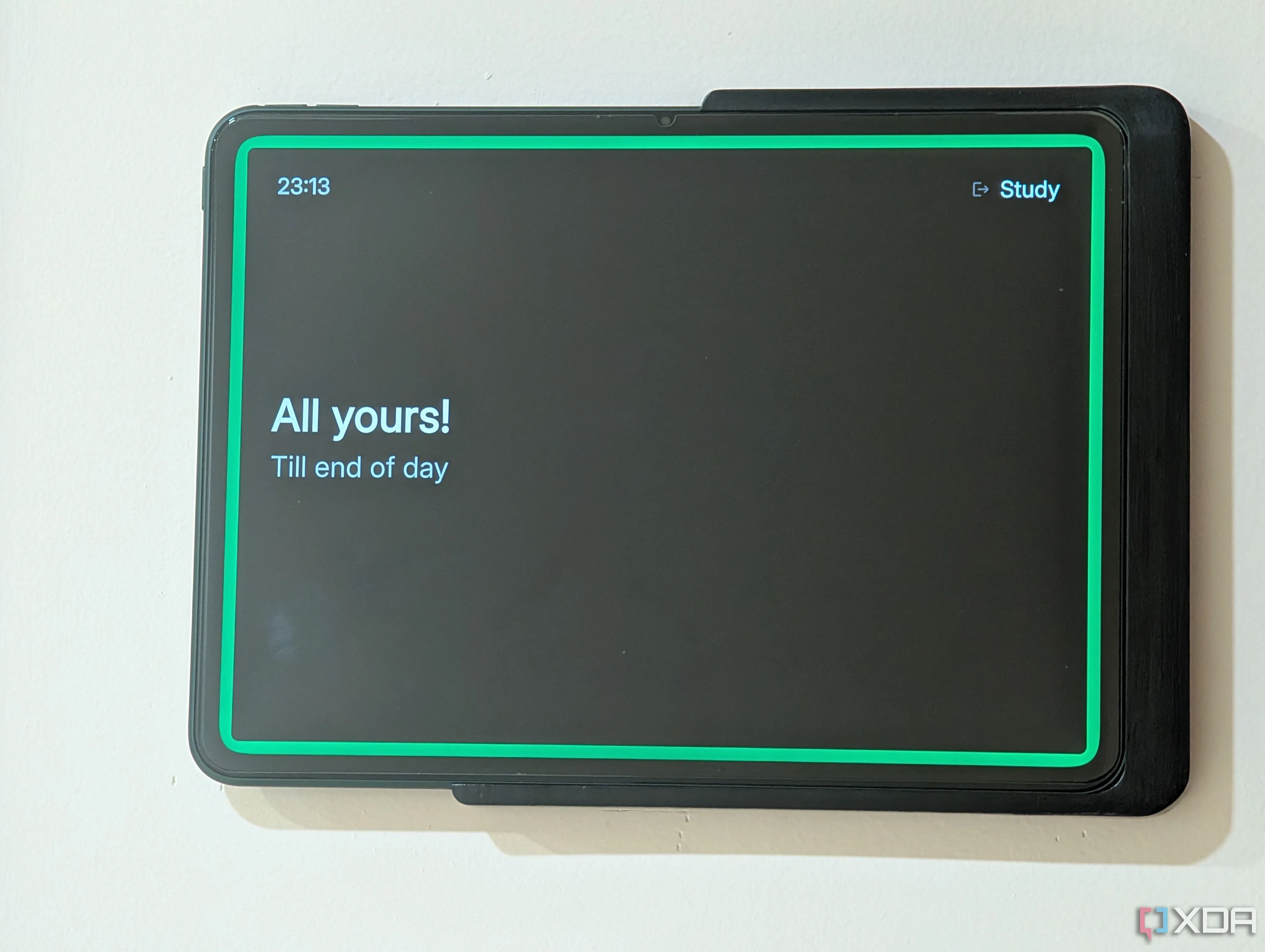 Hình ảnh cận cảnh chiếc tablet được gắn bên ngoài cửa văn phòng tại nhà, hiển thị trạng thái cuộc họp bằng ứng dụng Spacepad