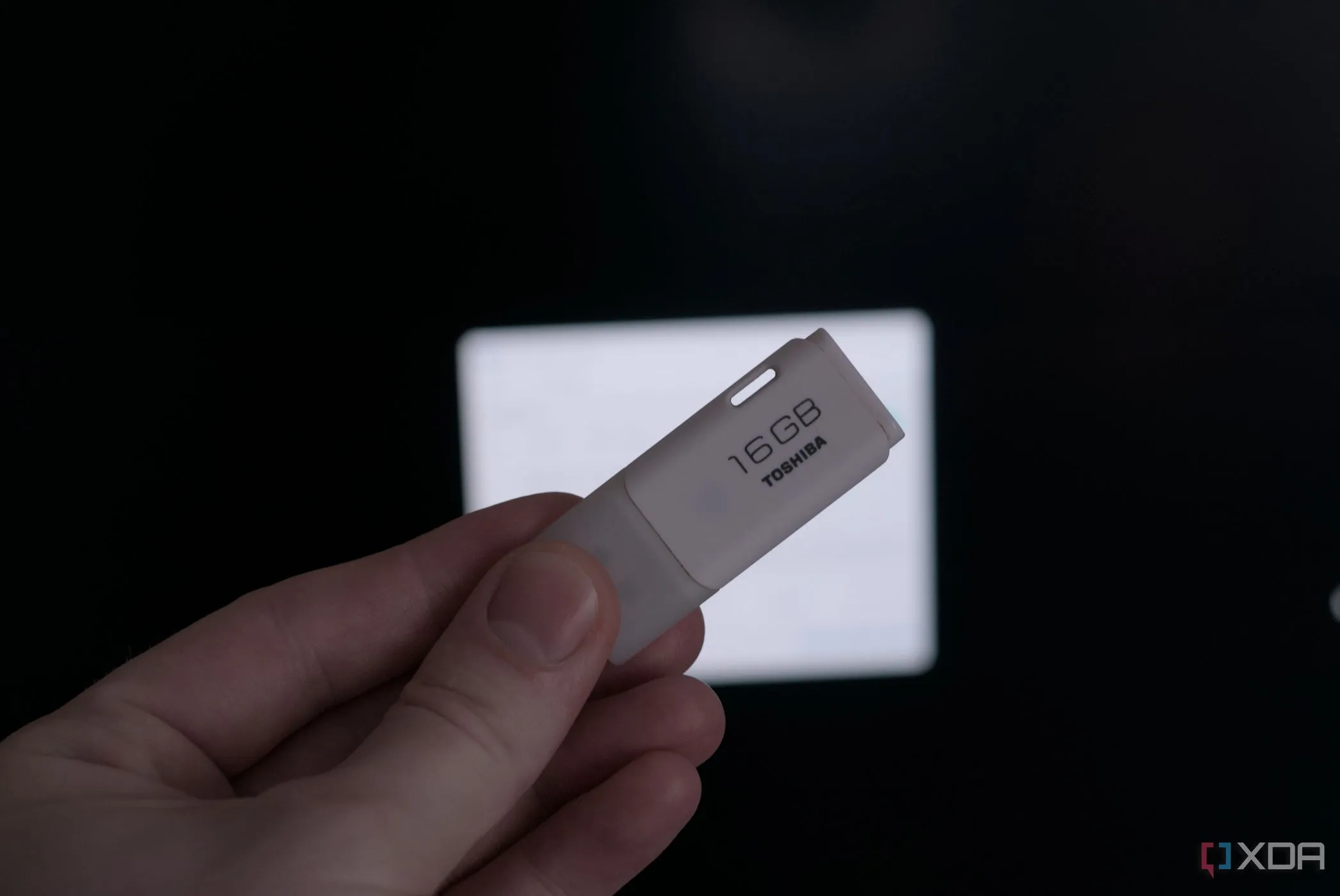Hình ảnh một bàn tay đang cầm USB flash drive, tượng trưng cho mối nguy hiểm từ các thiết bị USB không rõ nguồn gốc.