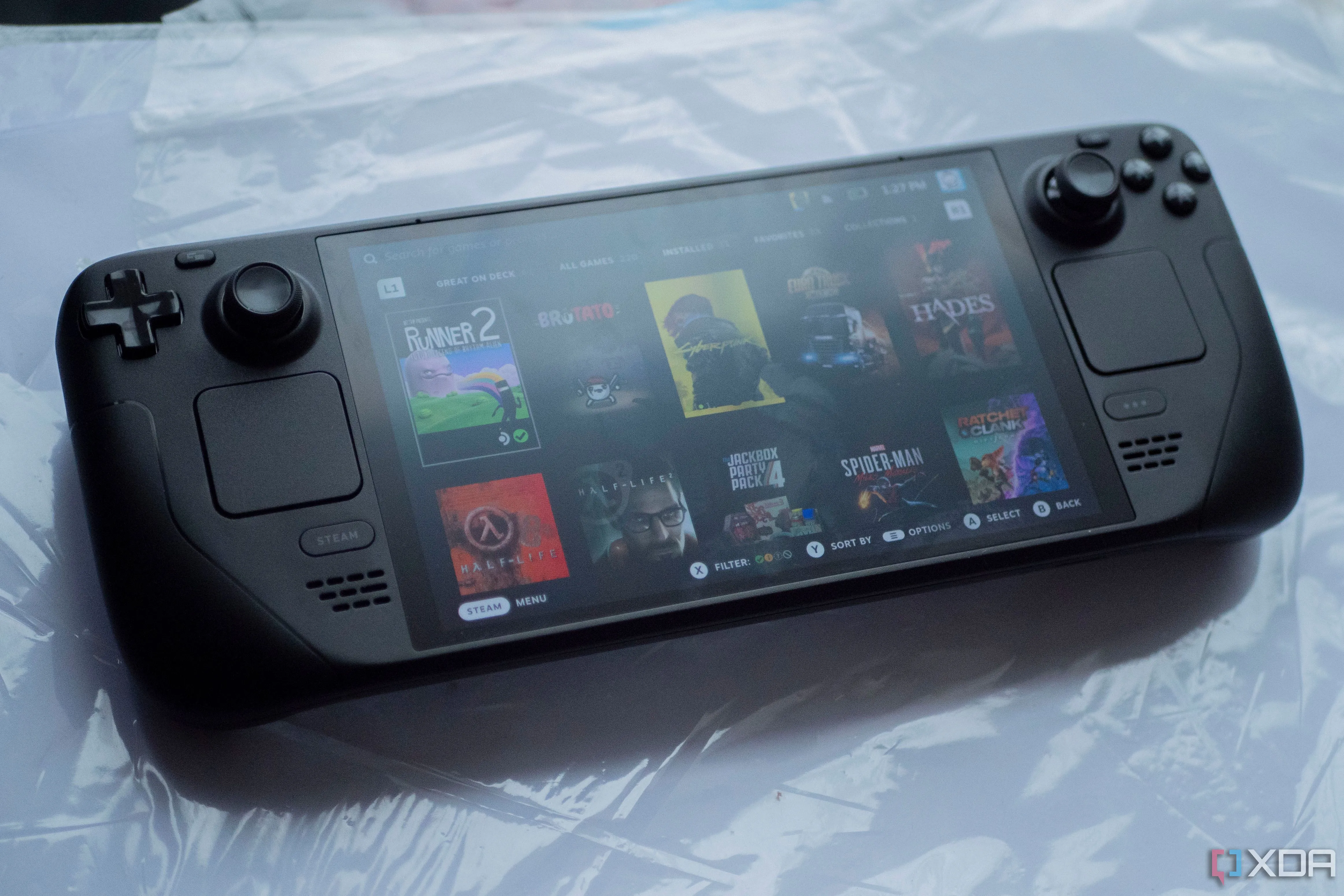 Hình ảnh Steam Deck OLED hiển thị nhiều tựa game trên màn hình, tượng trưng cho trải nghiệm game thủ và thư viện game Steam đồ sộ.