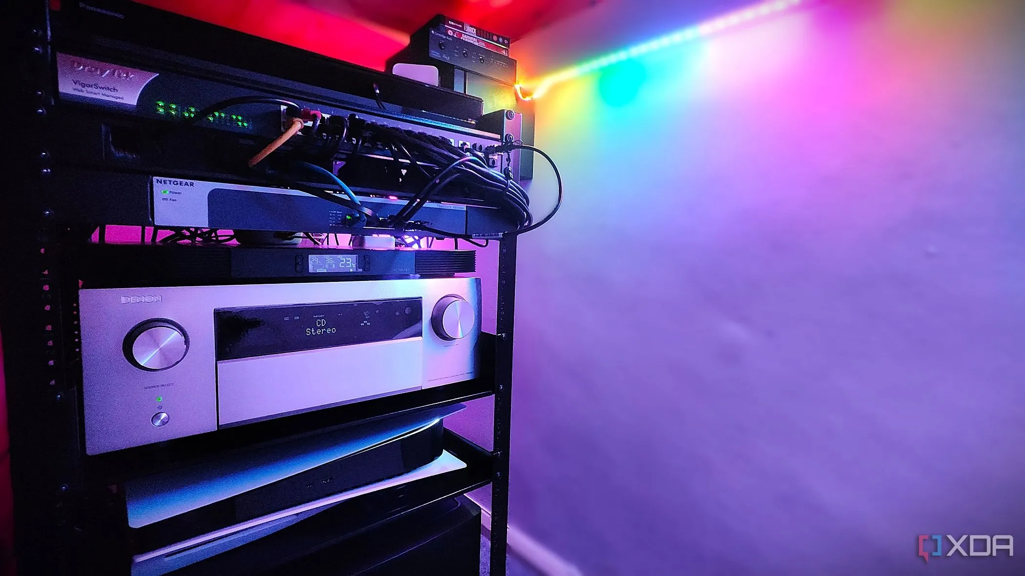 Kệ thiết bị âm thanh video với Denon AVR, PS5 và nhiều switch mạng, thể hiện khả năng tùy chỉnh mạng