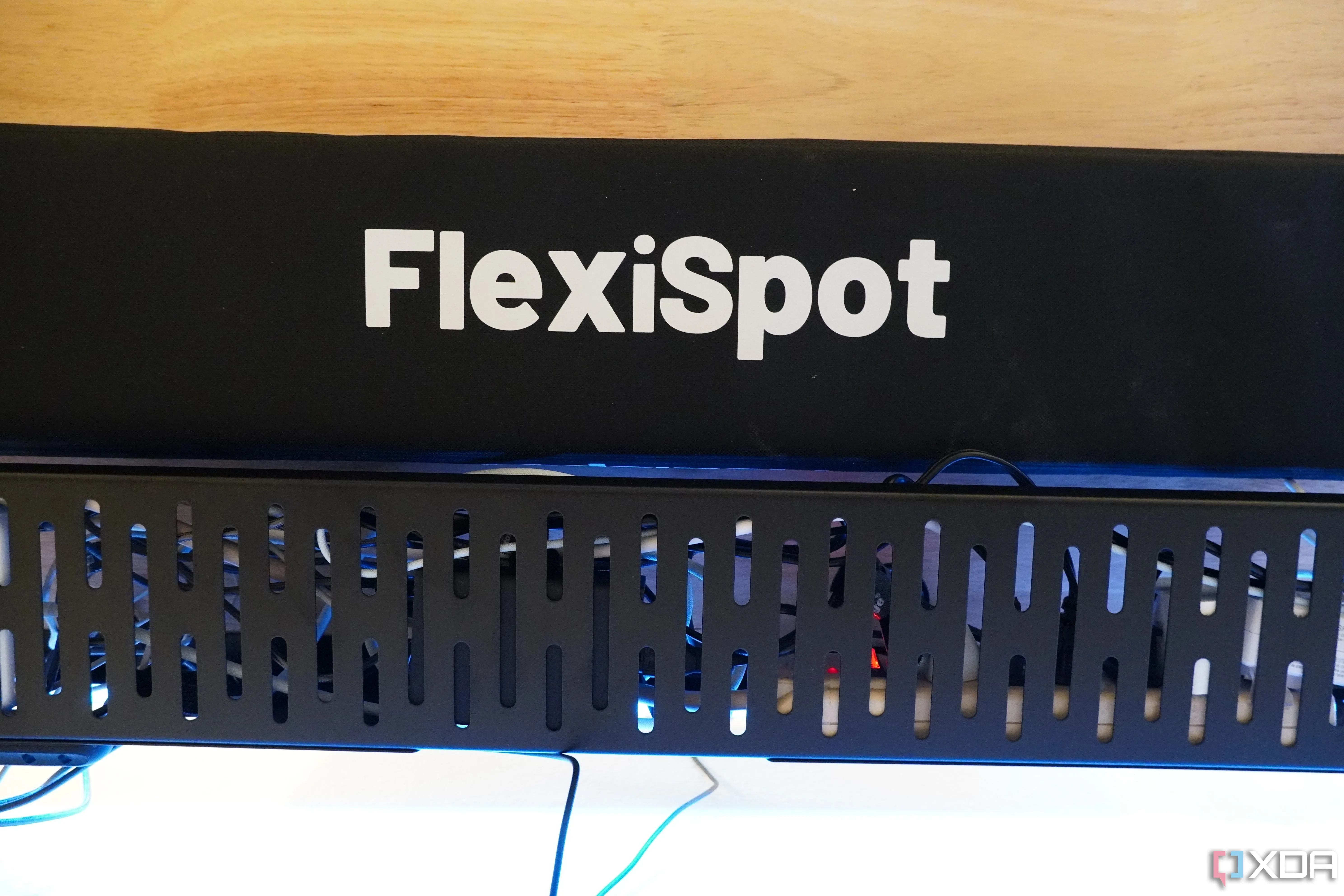 Khay quản lý cáp FlexiSpot và ống bọc cáp được lắp đặt dưới bàn làm việc, giúp giấu gọn dây điện và tạo không gian làm việc sạch sẽ.