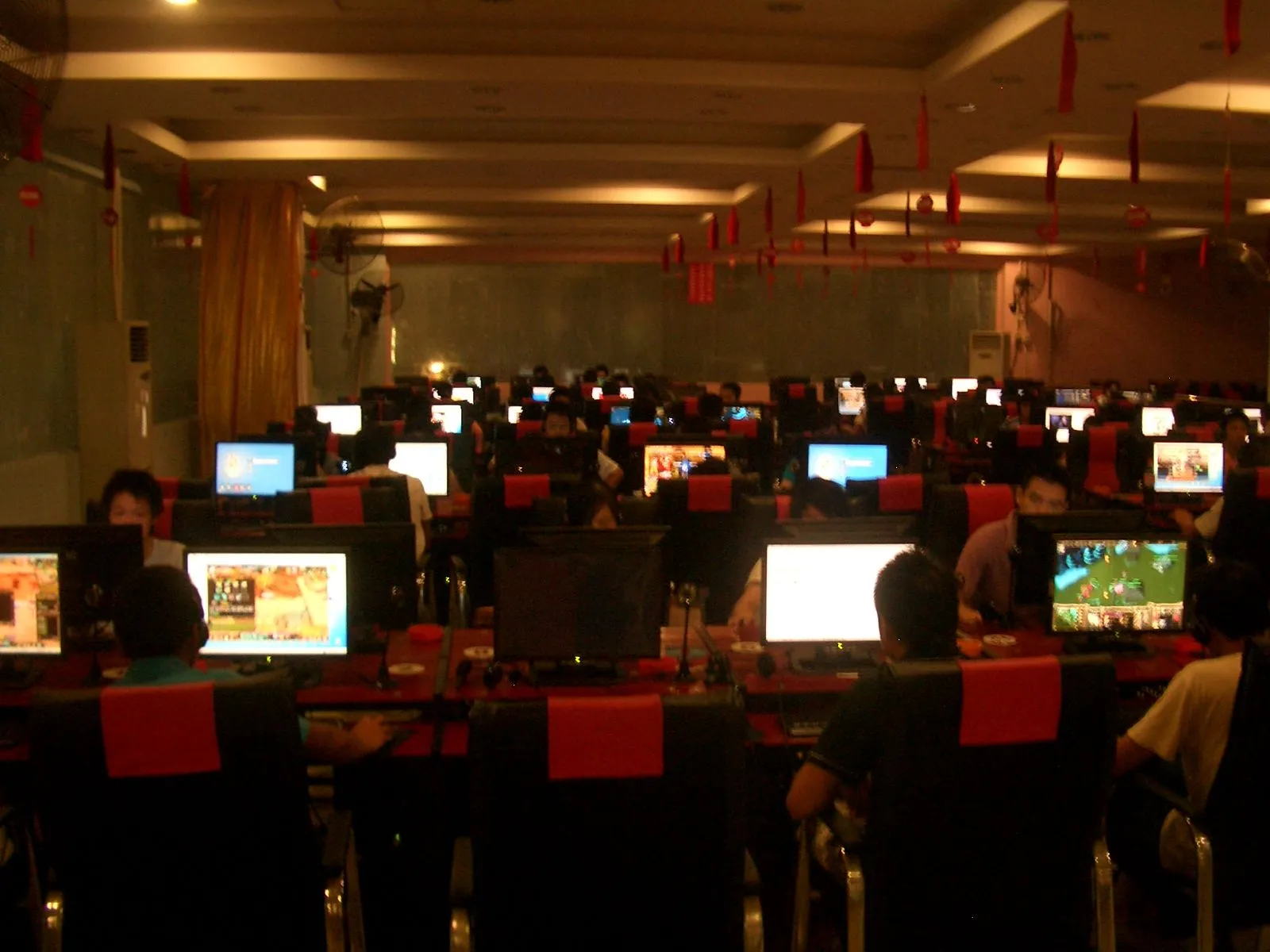 Không gian đông đúc bên trong một cybercafé ở châu Á, nơi người dùng có thể tham gia khảo sát Steam bằng các cấu hình PC đa dạng.