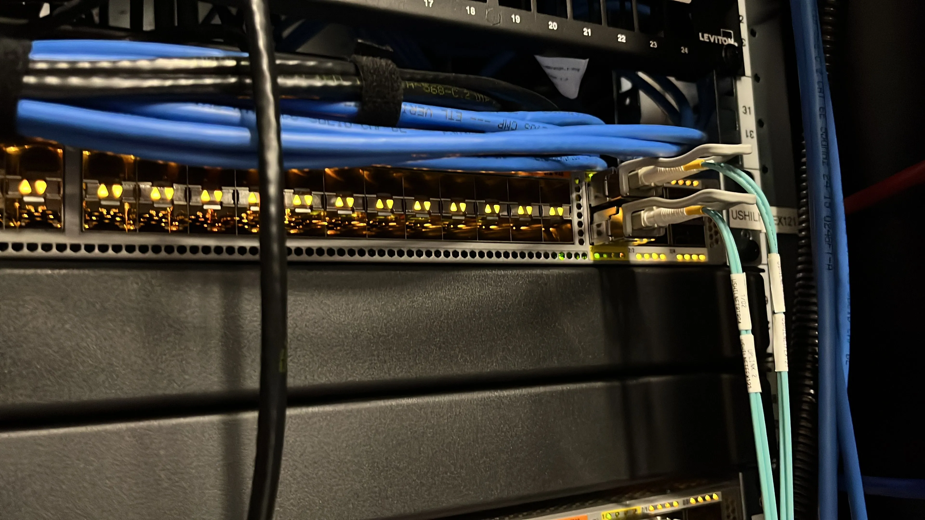 Kỹ thuật viên quản lý dây cáp gọn gàng trên switch mạng, tượng trưng cho quản trị an ninh mạng home lab