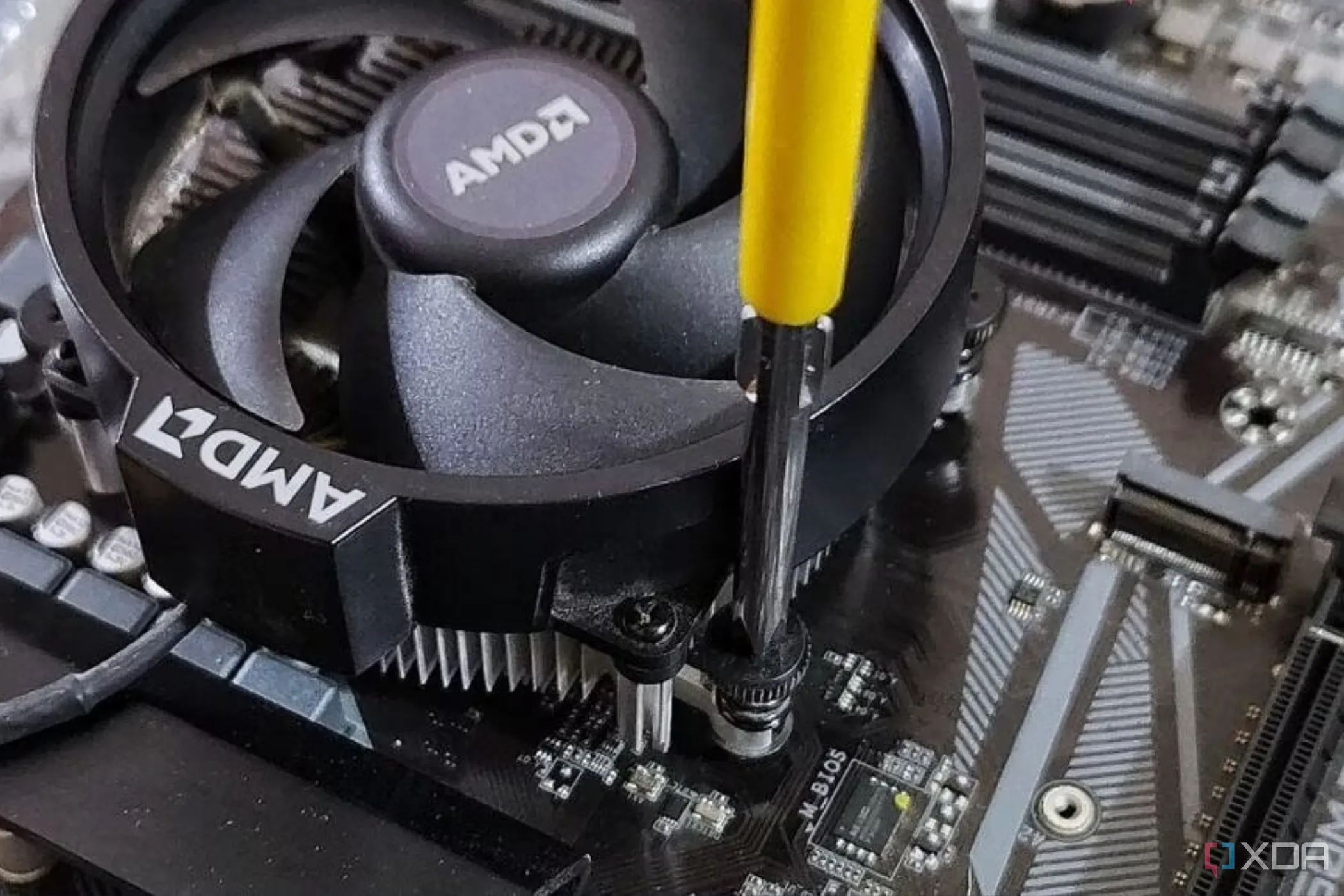 Lắp tản nhiệt CPU AMD mặc định vào bo mạch chủ bằng tuốc nơ vít chuyên dụng.