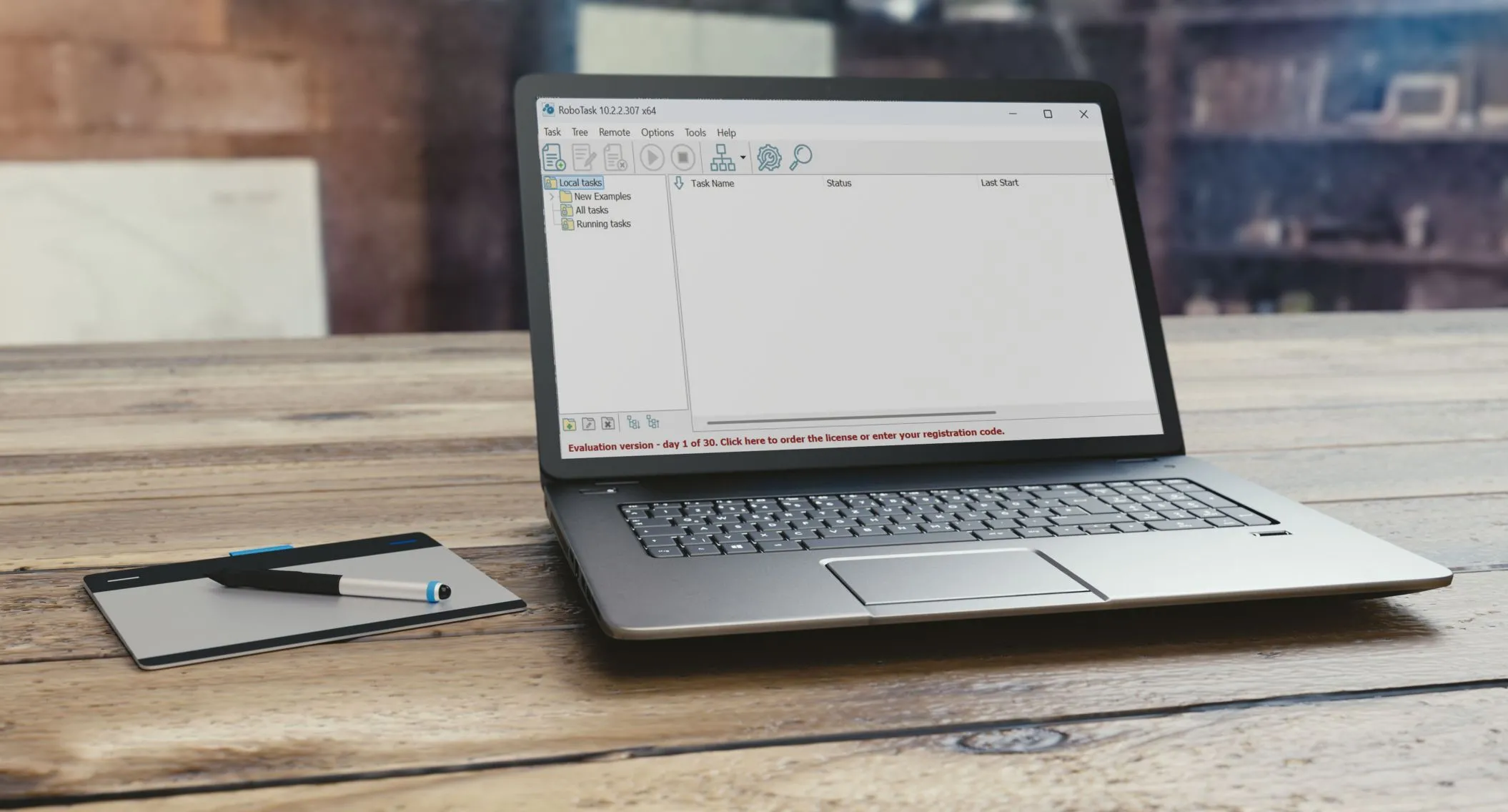 Laptop với ứng dụng RoboTask đang mở, đặt trên bàn gỗ