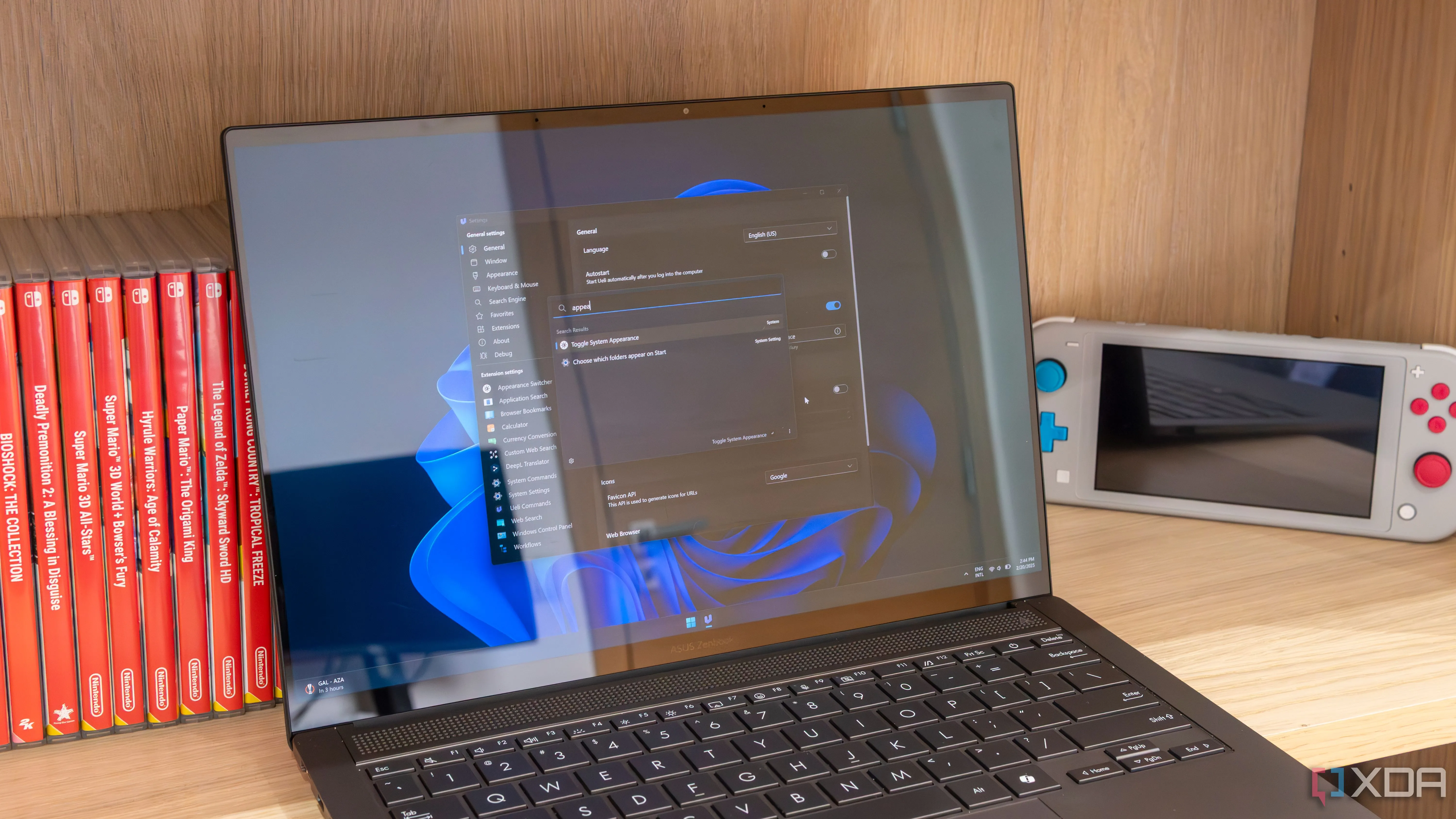 Laptop Windows 11 hiển thị cửa sổ cài đặt và thanh tìm kiếm của Ueli