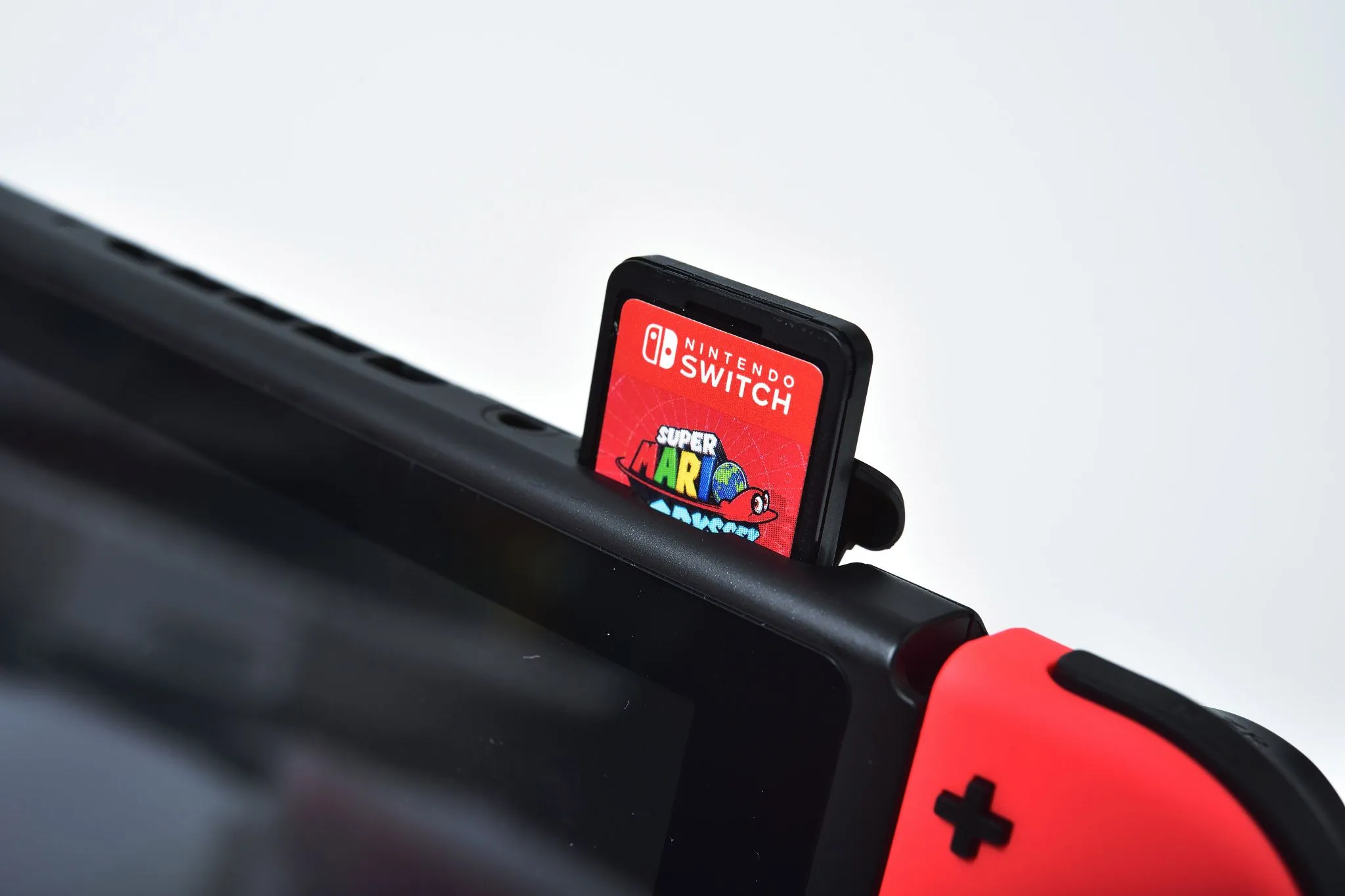 Máy chơi game Nintendo Switch với thẻ game được lắp vào khe cắm, liên quan đến các quyết định kinh doanh của Nintendo về định dạng game