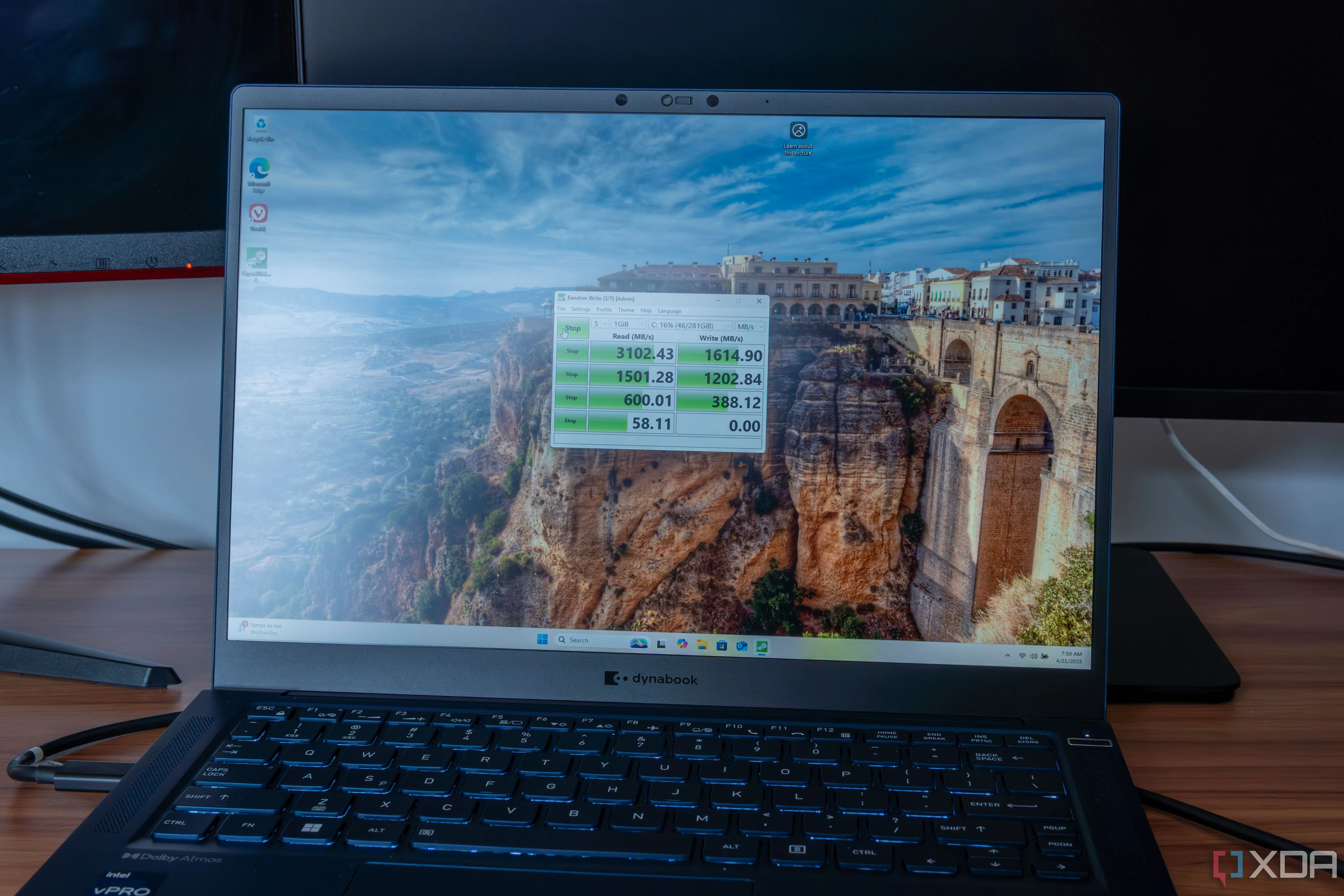 Máy tính xách tay Windows 11 đang chạy bài kiểm tra hiệu năng ổ đĩa CrystalDiskMark