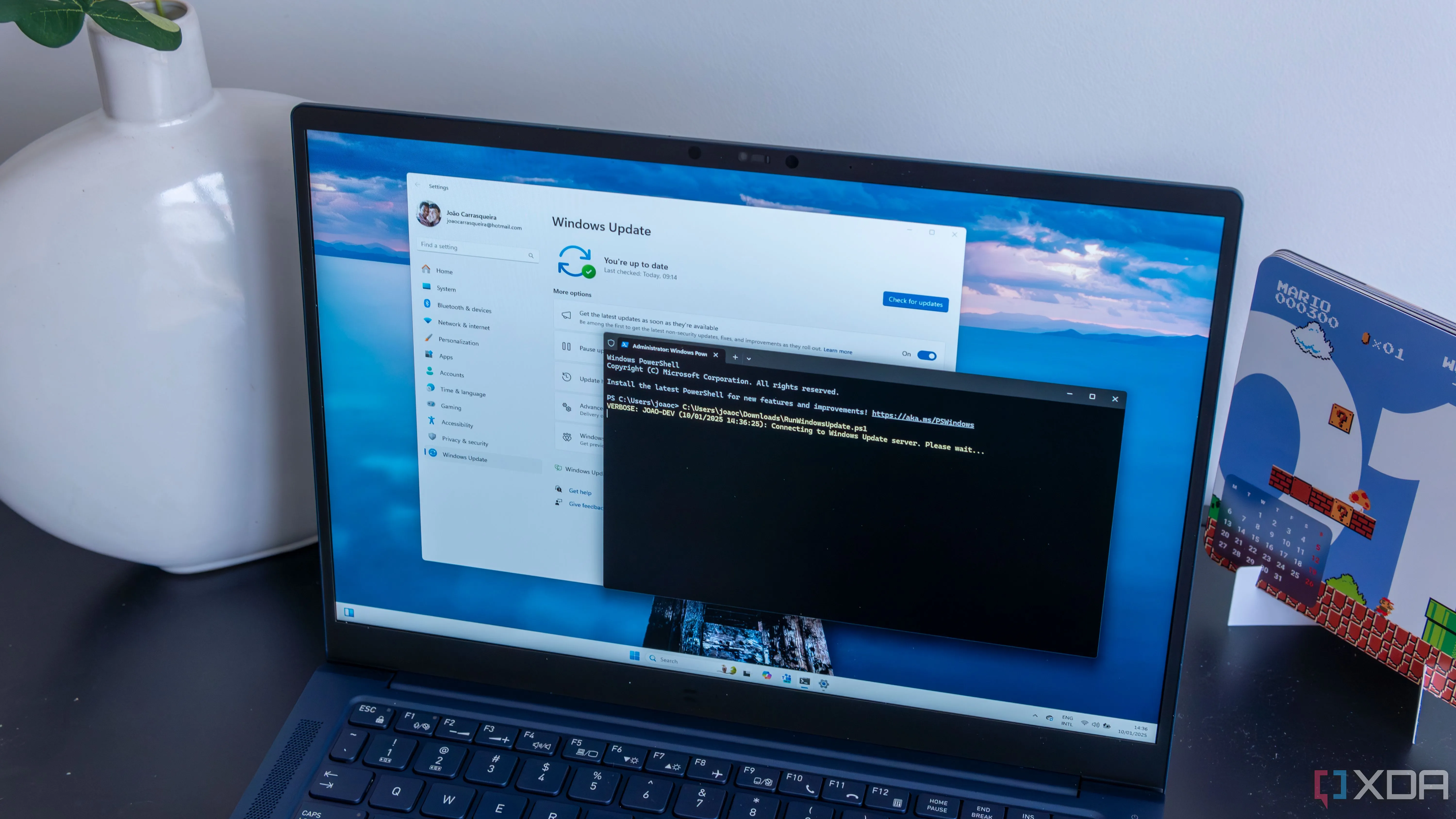 Máy tính xách tay Windows 11 đang chạy script PowerShell để tự động cài đặt các bản cập nhật và khởi động lại.
