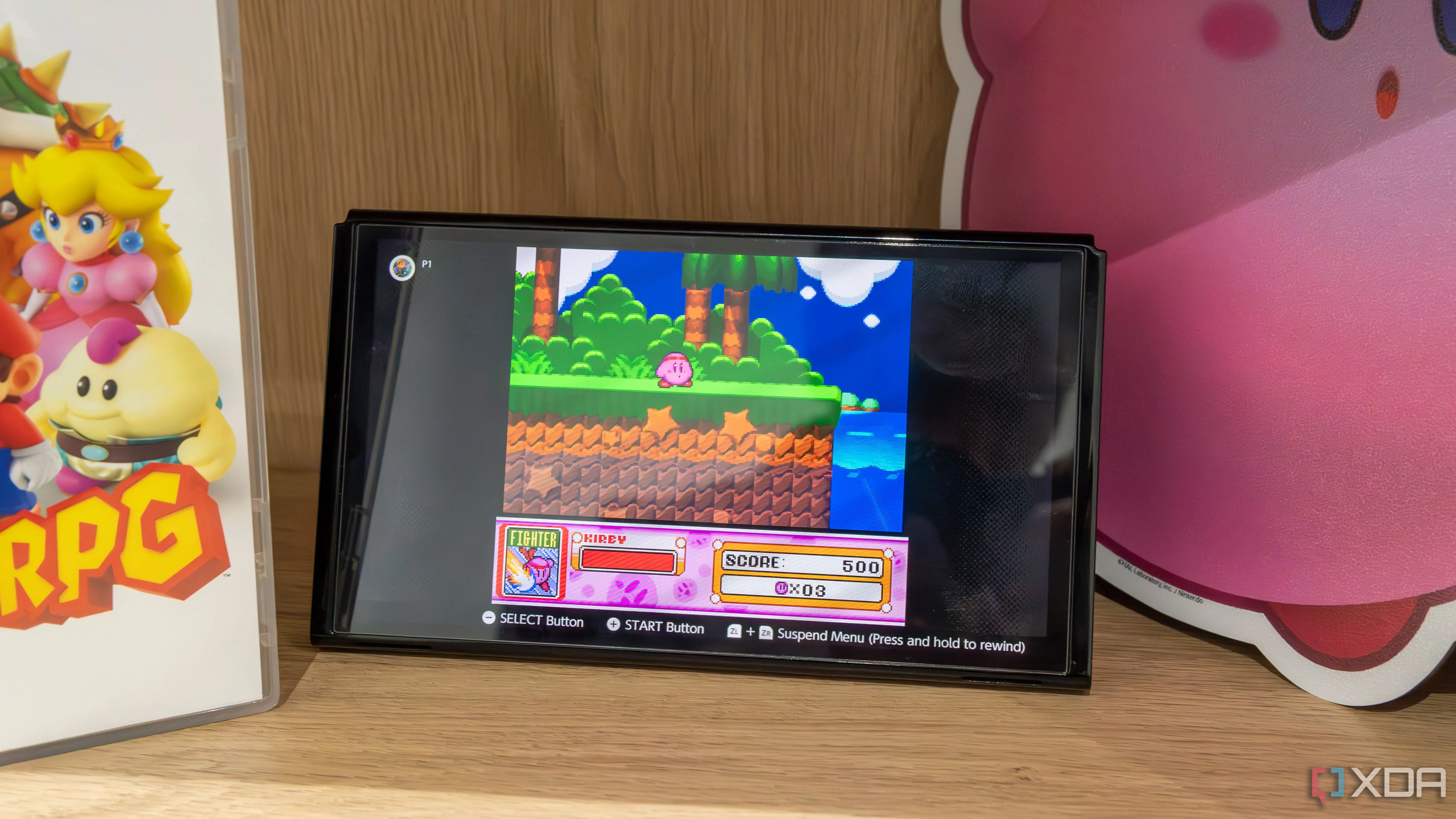 Một chiếc Nintendo Switch OLED đang chơi game Kirby Super Star trên ứng dụng SNES Online, minh họa sự thư giãn của các tựa game kinh điển