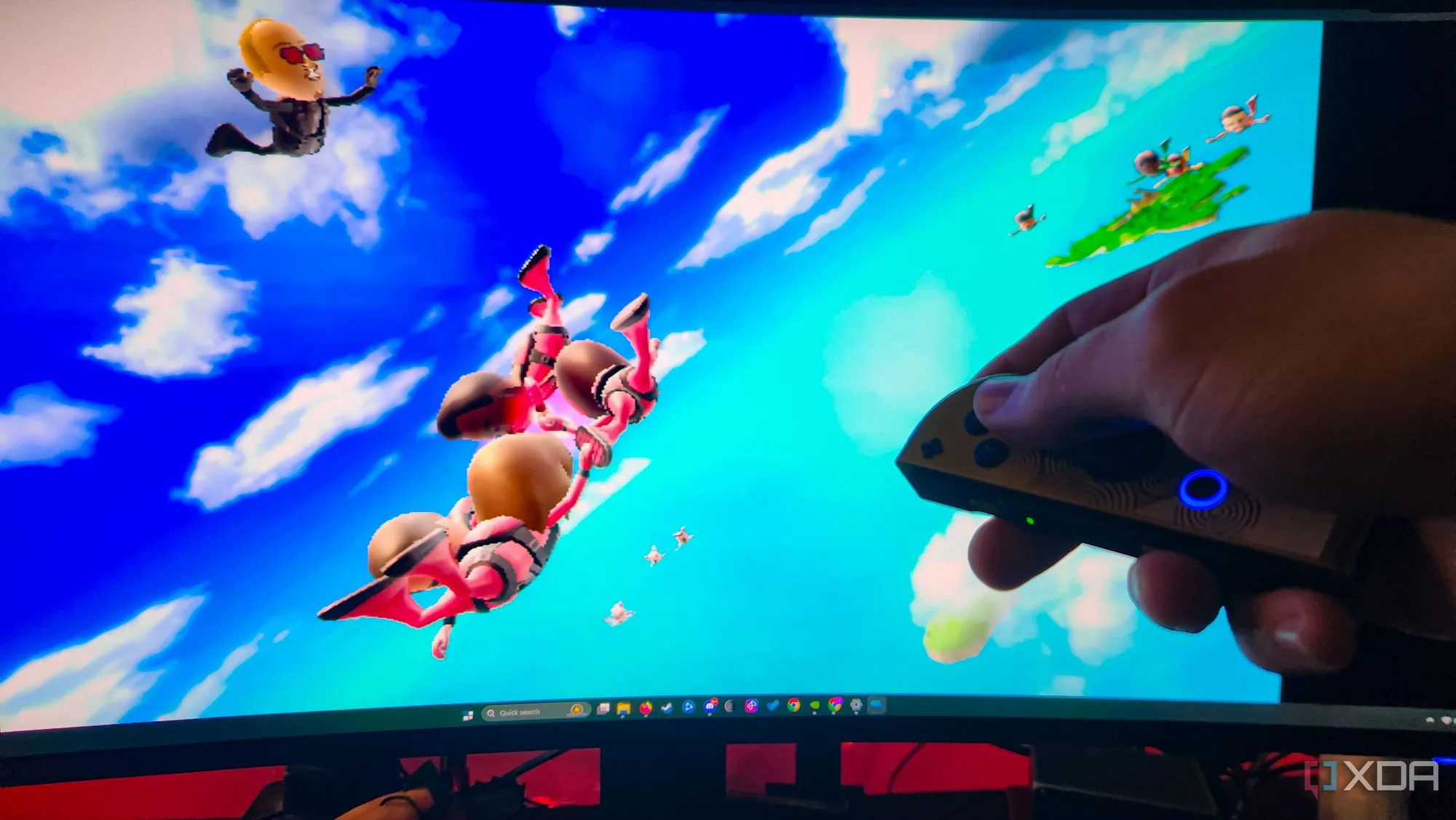 Một chiếc tay cầm Joy-Con màu xanh và đỏ được đặt trên mặt bàn cạnh một chiếc điện thoại, minh họa sự linh hoạt và tiện lợi khi sử dụng Joy-Cons để chơi game PC.