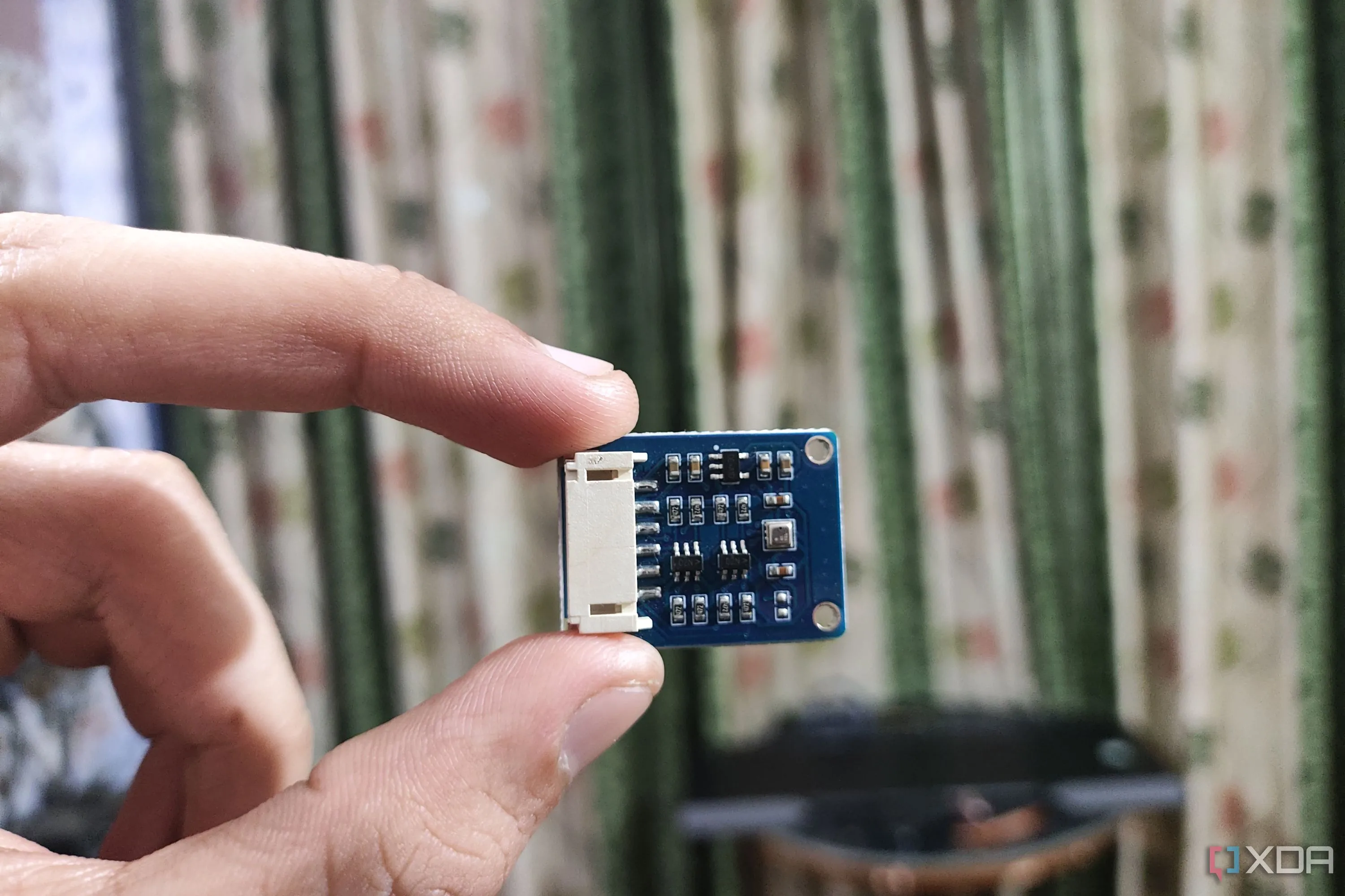 Một người đang cầm cảm biến BME280, thiết bị thường được dùng để đo nhiệt độ và độ ẩm môi trường