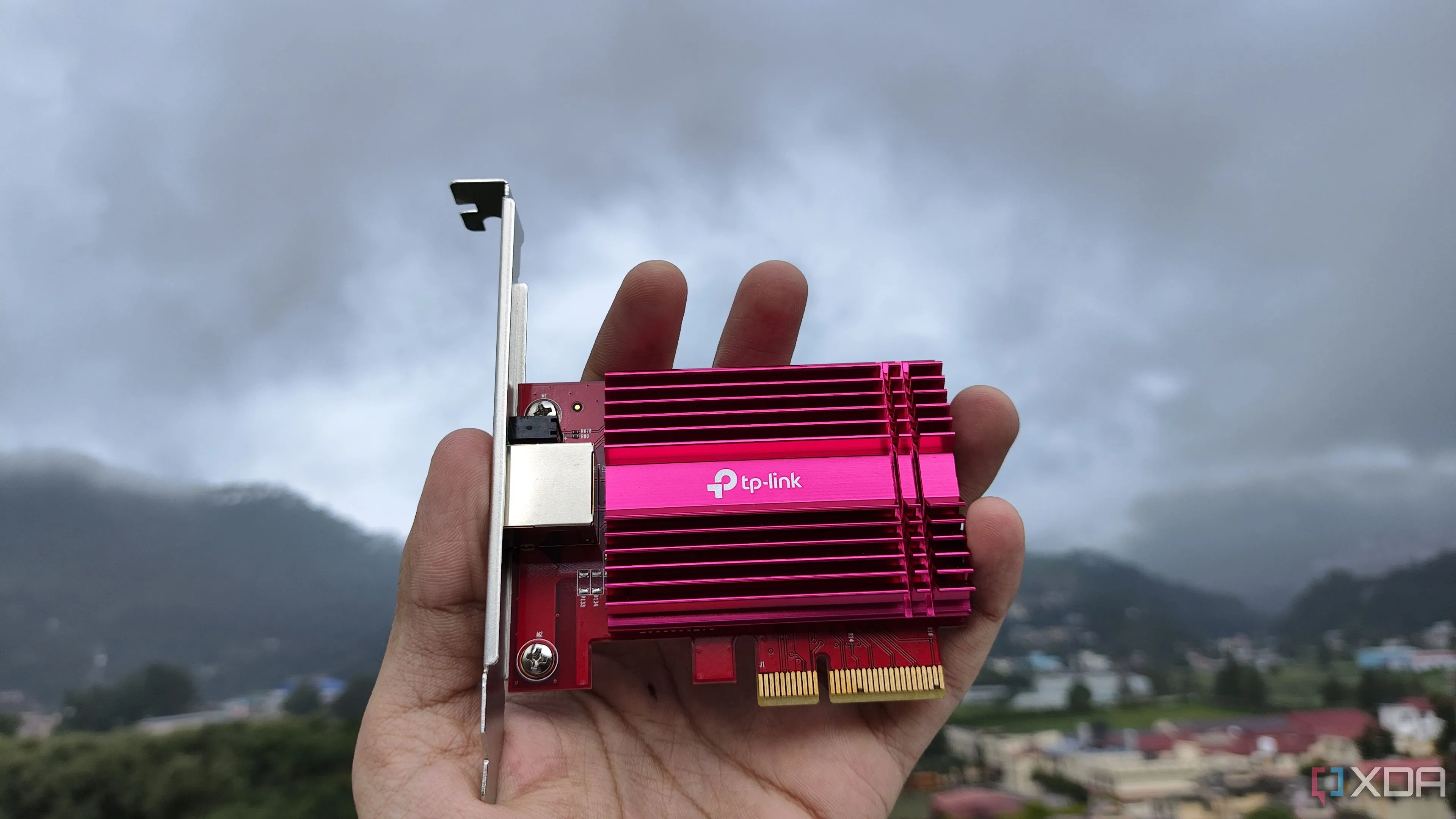 Một người đang cầm card mạng TP-Link 10G NIC, minh họa việc lựa chọn phần cứng chất lượng cho router tự dựng OPNsense để tăng hiệu suất