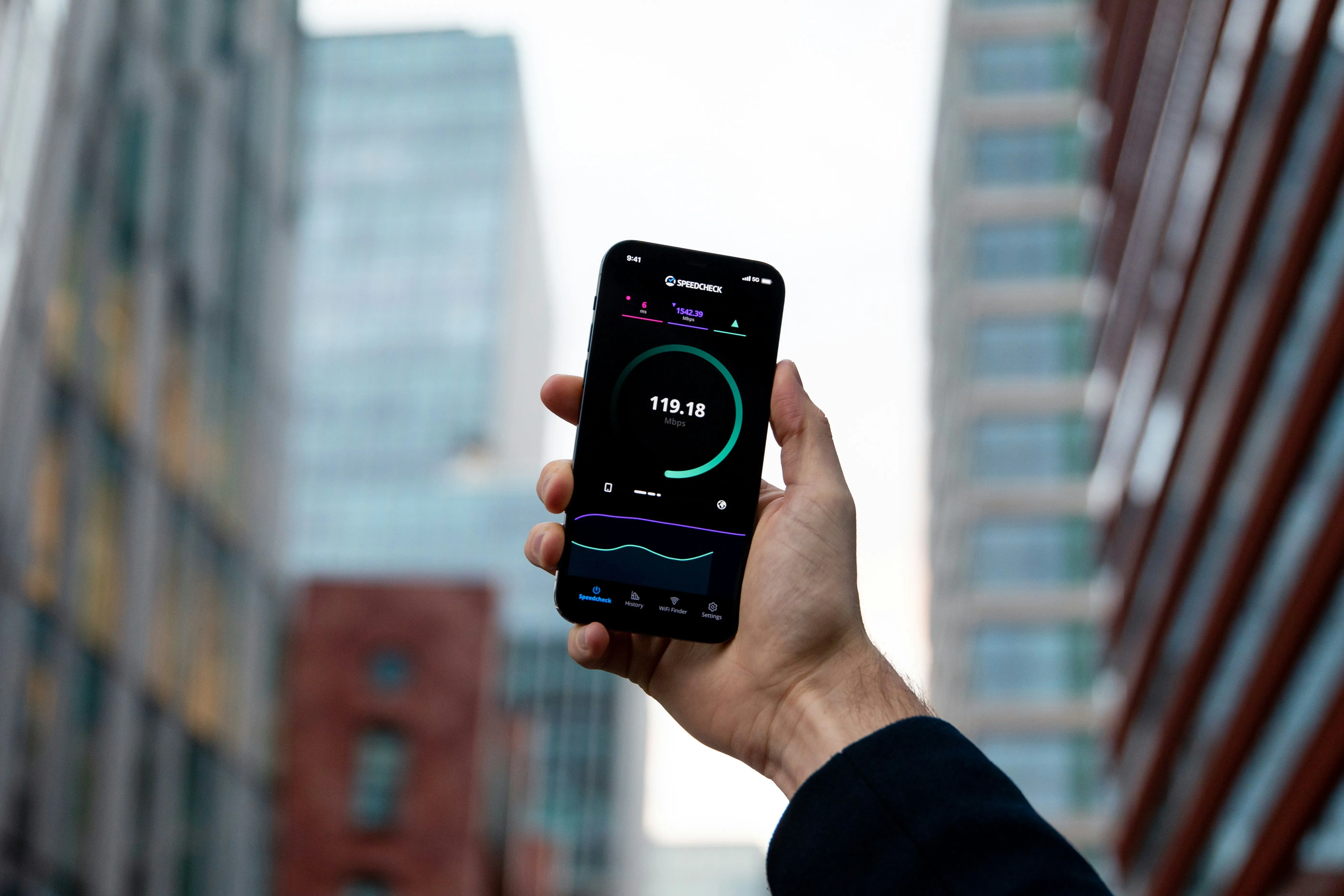 Một người đang cầm smartphone chạy ứng dụng kiểm tra tốc độ Wi-Fi, phản ánh hiệu suất chậm khi sử dụng router cũ đã tái chế.