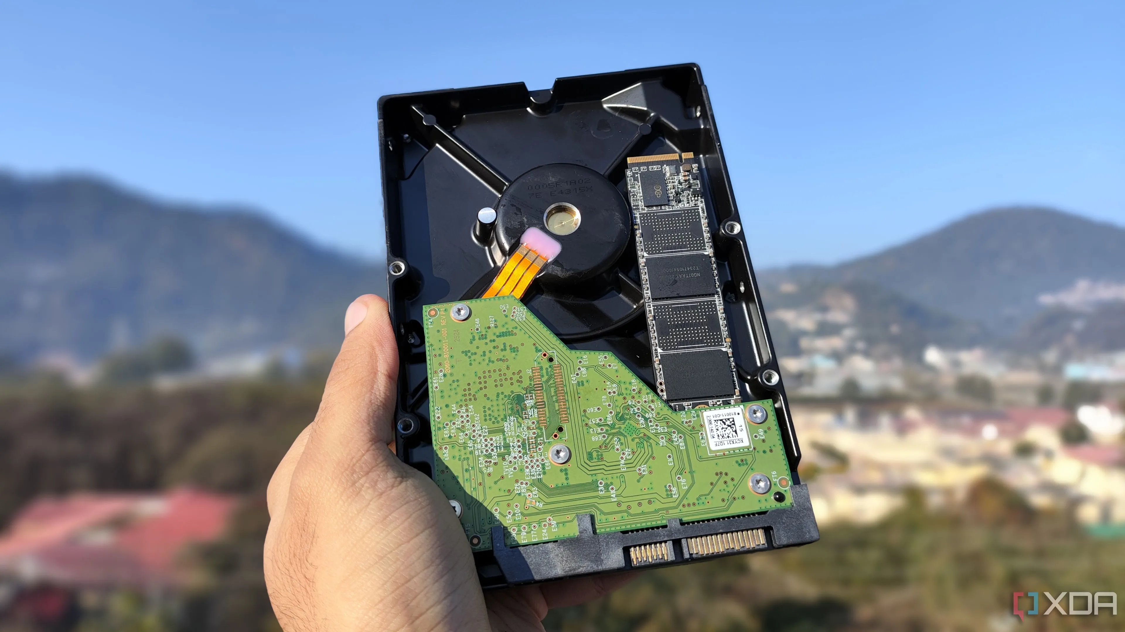 Một người đang cầm so sánh ổ cứng HDD và ổ cứng SSD, minh họa sự khác biệt về kích thước và công nghệ lưu trữ