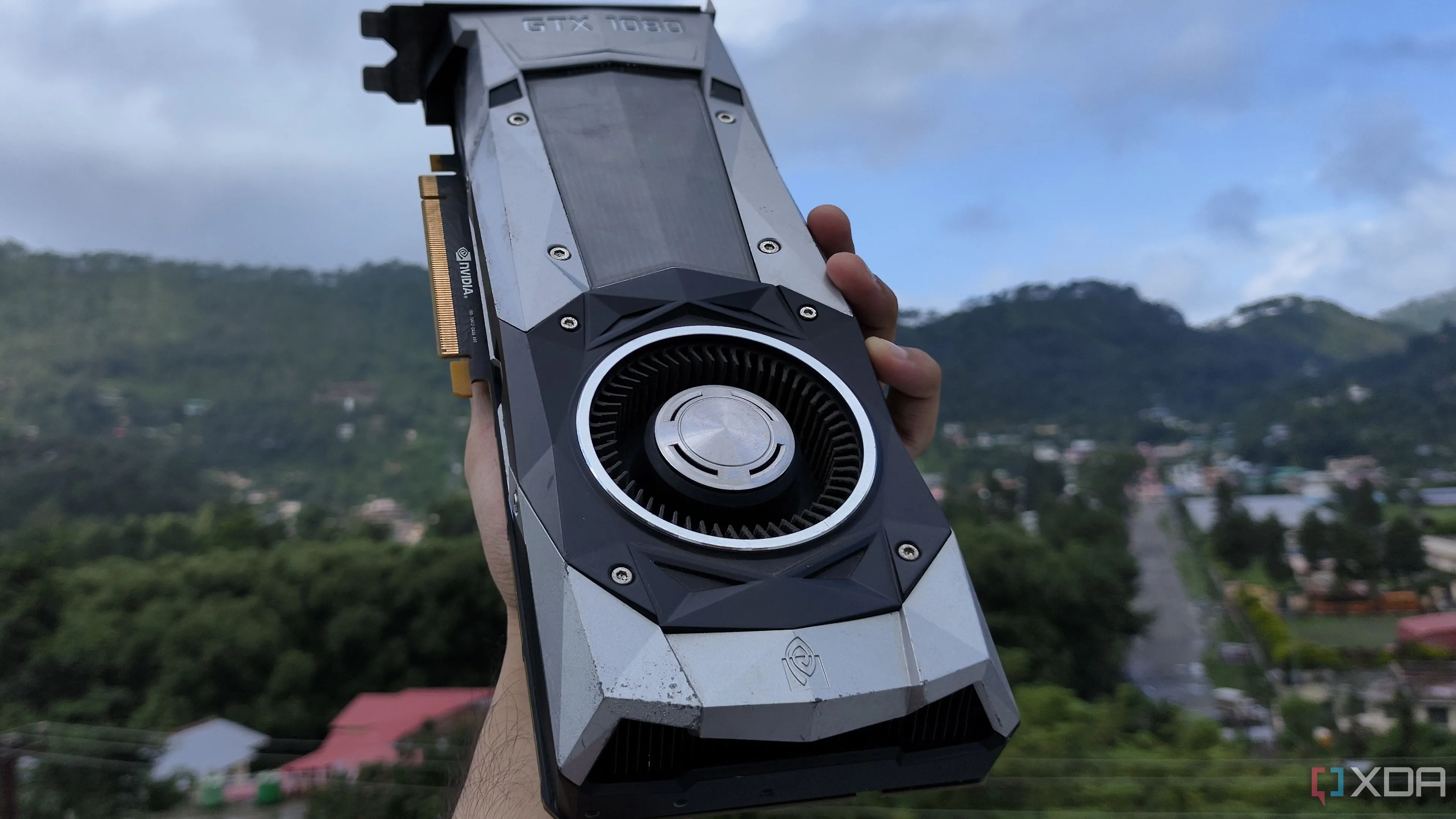 Một người dùng đang cầm card đồ họa NVIDIA GeForce GTX 1080 Founders Edition, biểu tượng của phần cứng PC trong cộng đồng game thủ.