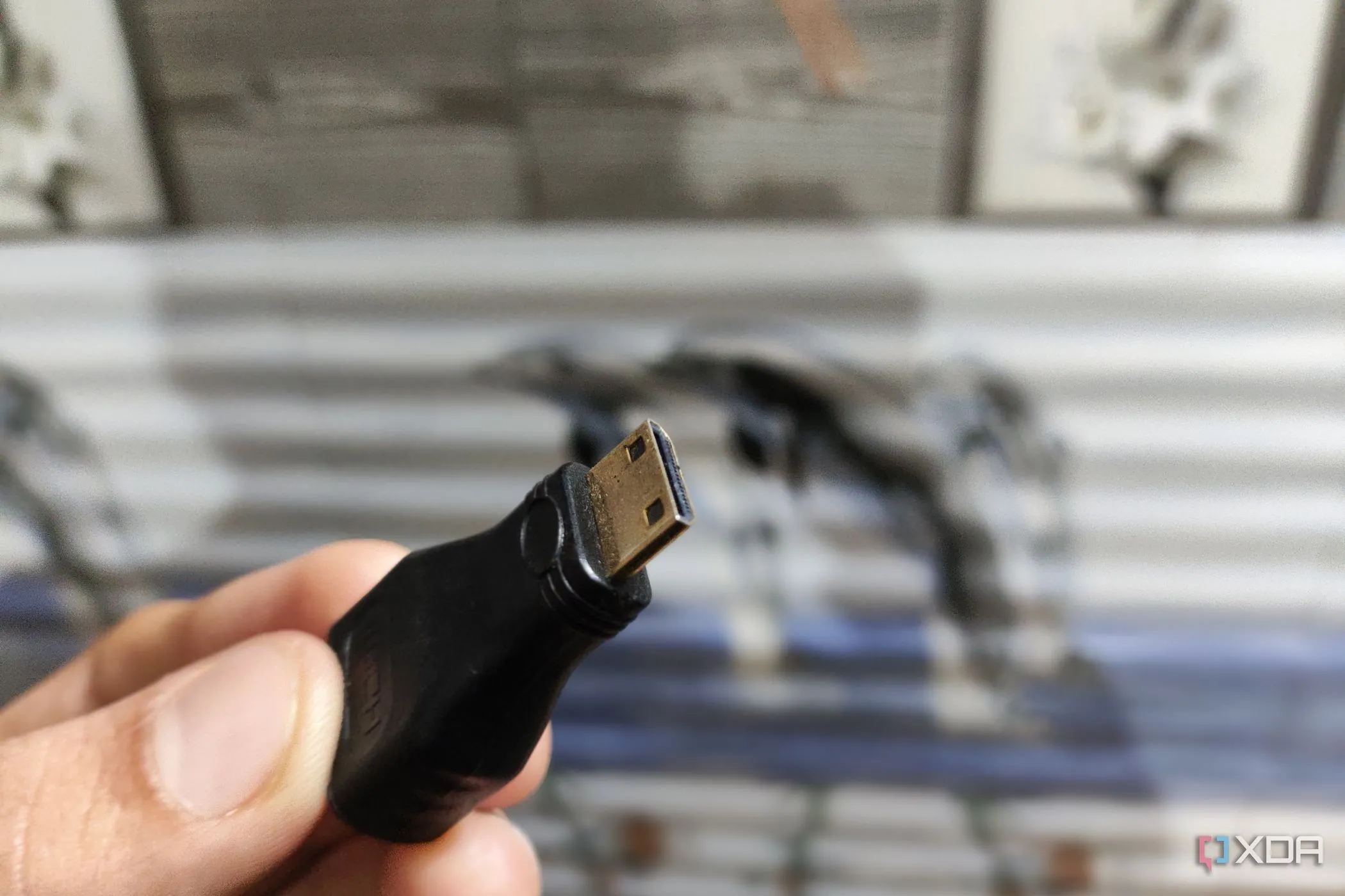 Người dùng cầm bộ chuyển đổi Mini HDMI sang HDMI, minh họa cho việc sử dụng cáp HDMI trong nhà