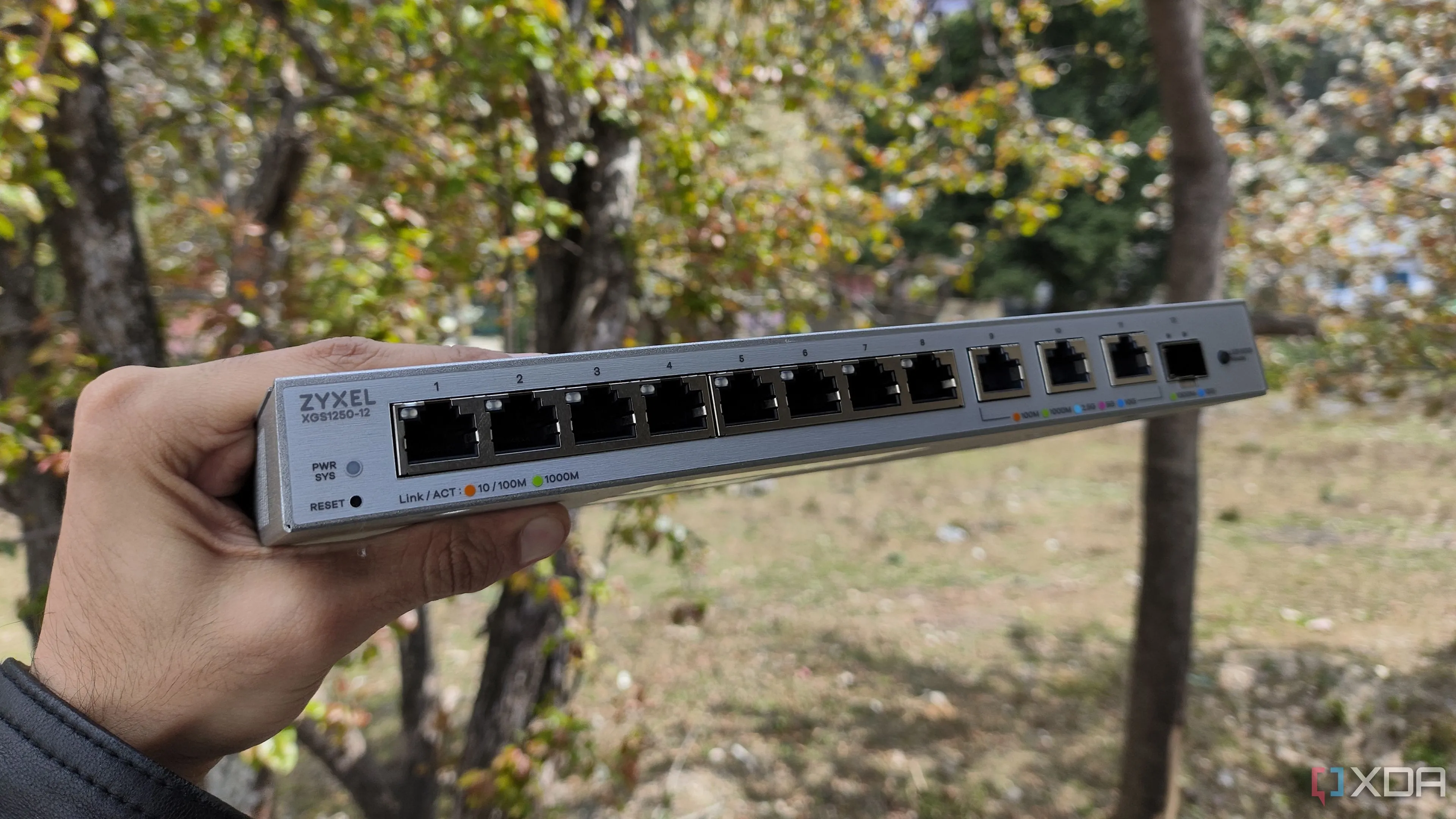 Người dùng đang cầm switch mạng Zyxel, thiết bị quan trọng giúp nâng cấp tốc độ mạng nội bộ