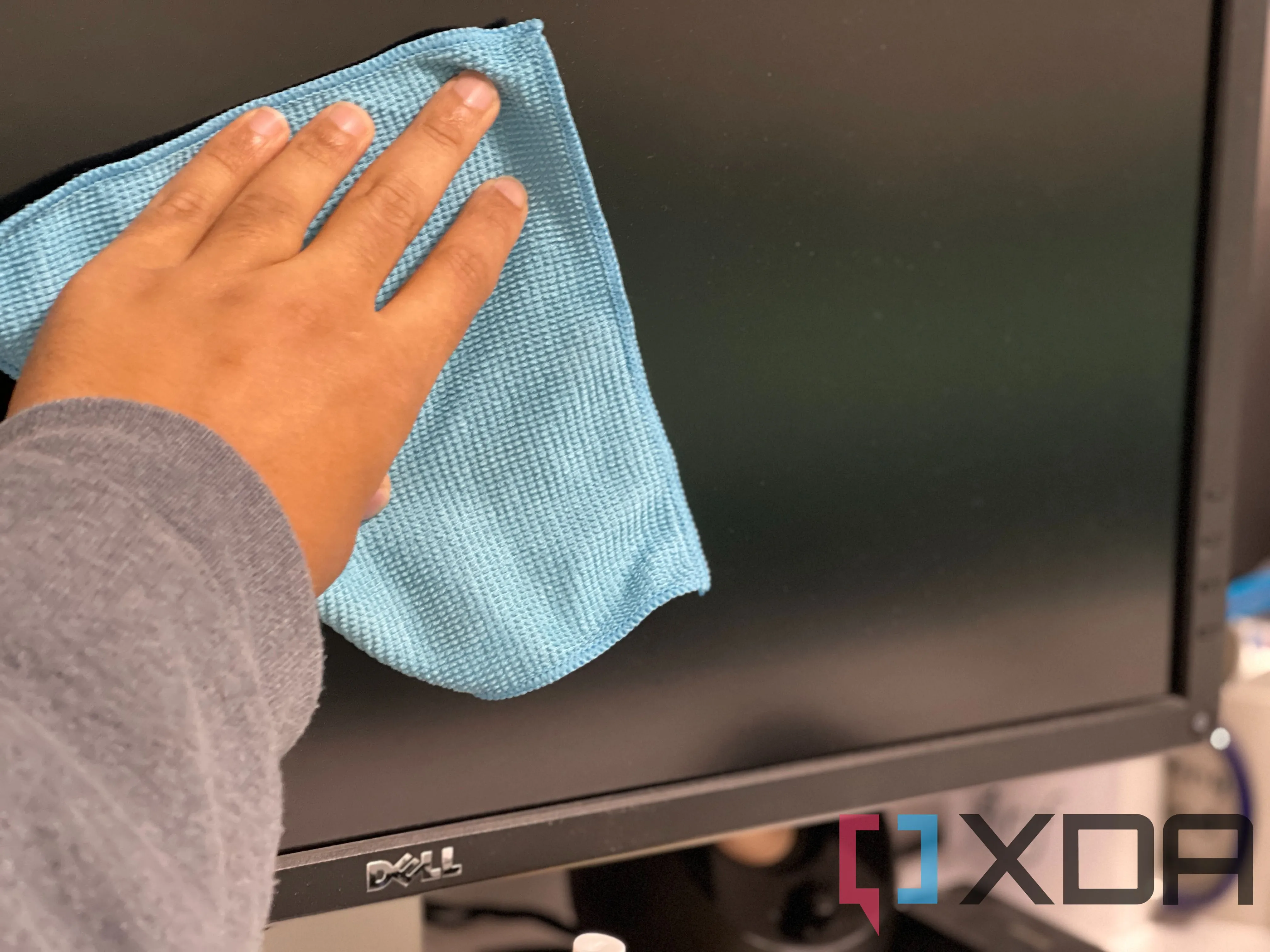Người dùng đang cẩn thận lau chùi bề mặt màn hình QD-OLED nhạy cảm