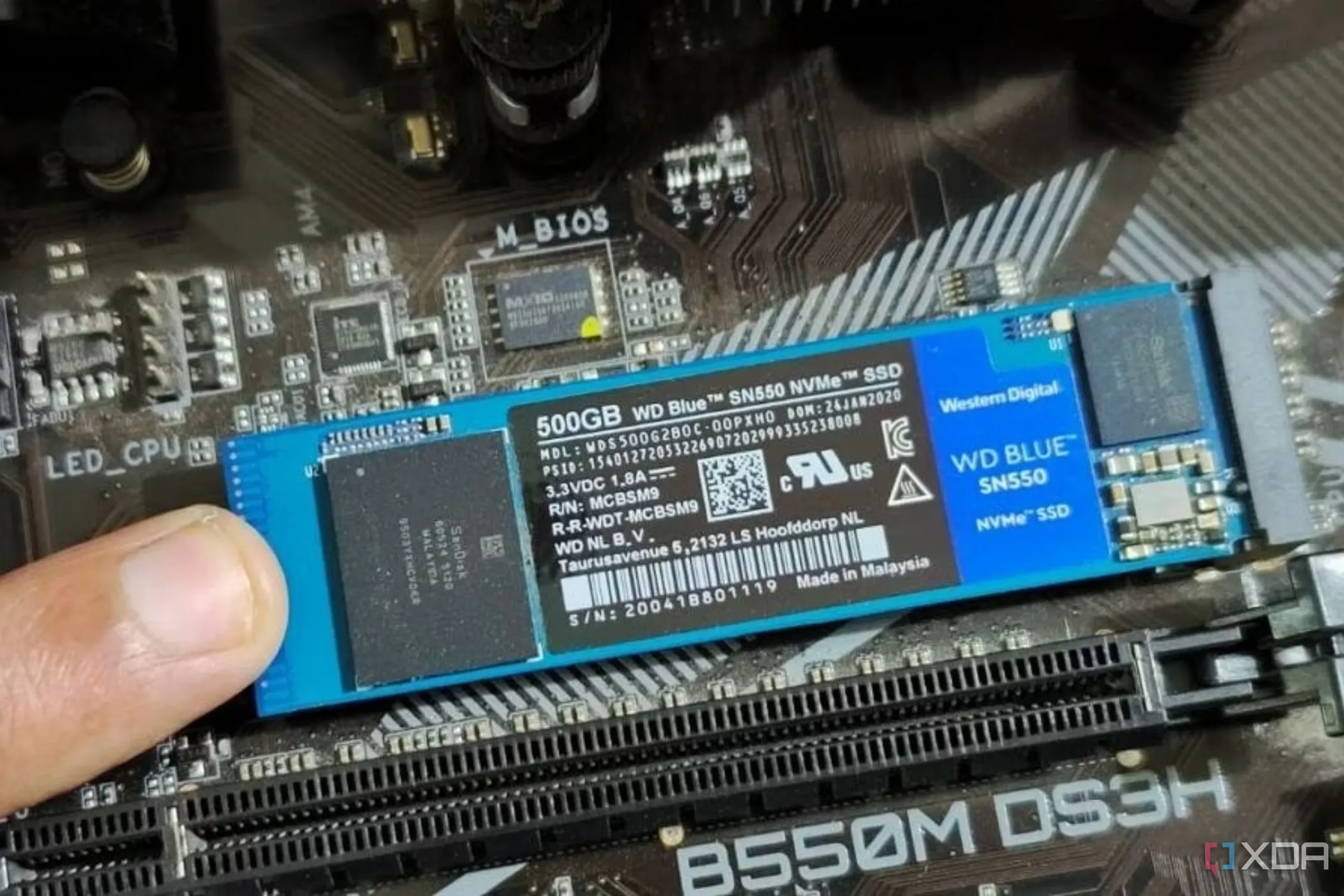 Người dùng đang giữ SSD M.2 trên bo mạch chủ
