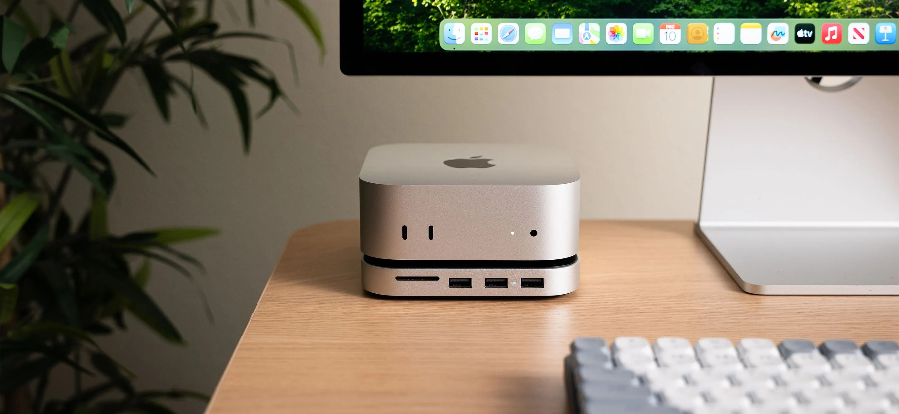 Phụ kiện Satechi Mac Mini M4 Stand &amp; Hub màu xám đặt dưới Mac Mini, hiển thị các cổng kết nối và khe cắm SSD