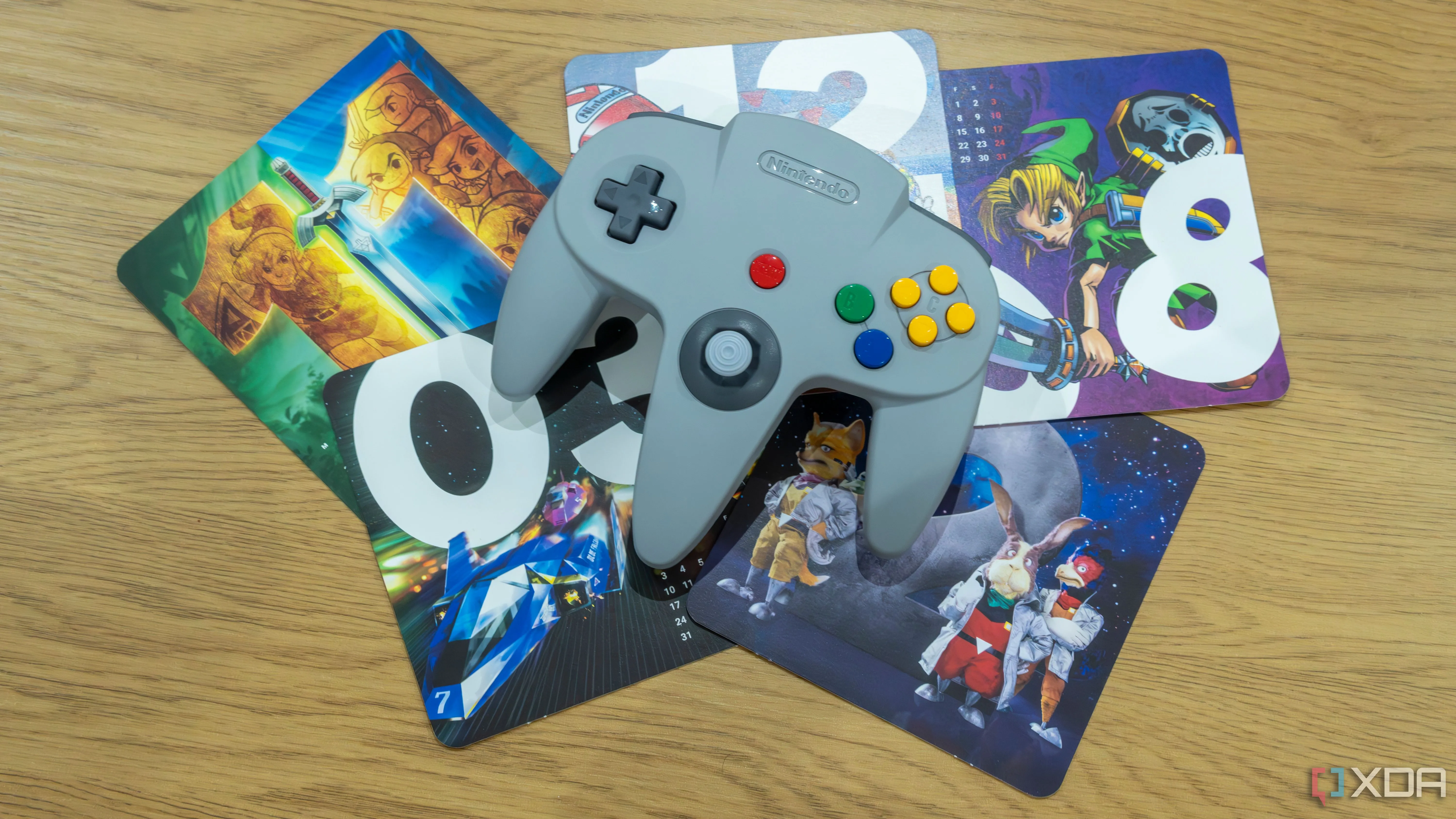 Tay cầm Nintendo 64 với các hình ảnh game N64 kinh điển làm nền, gợi nhớ kỷ nguyên vàng của console