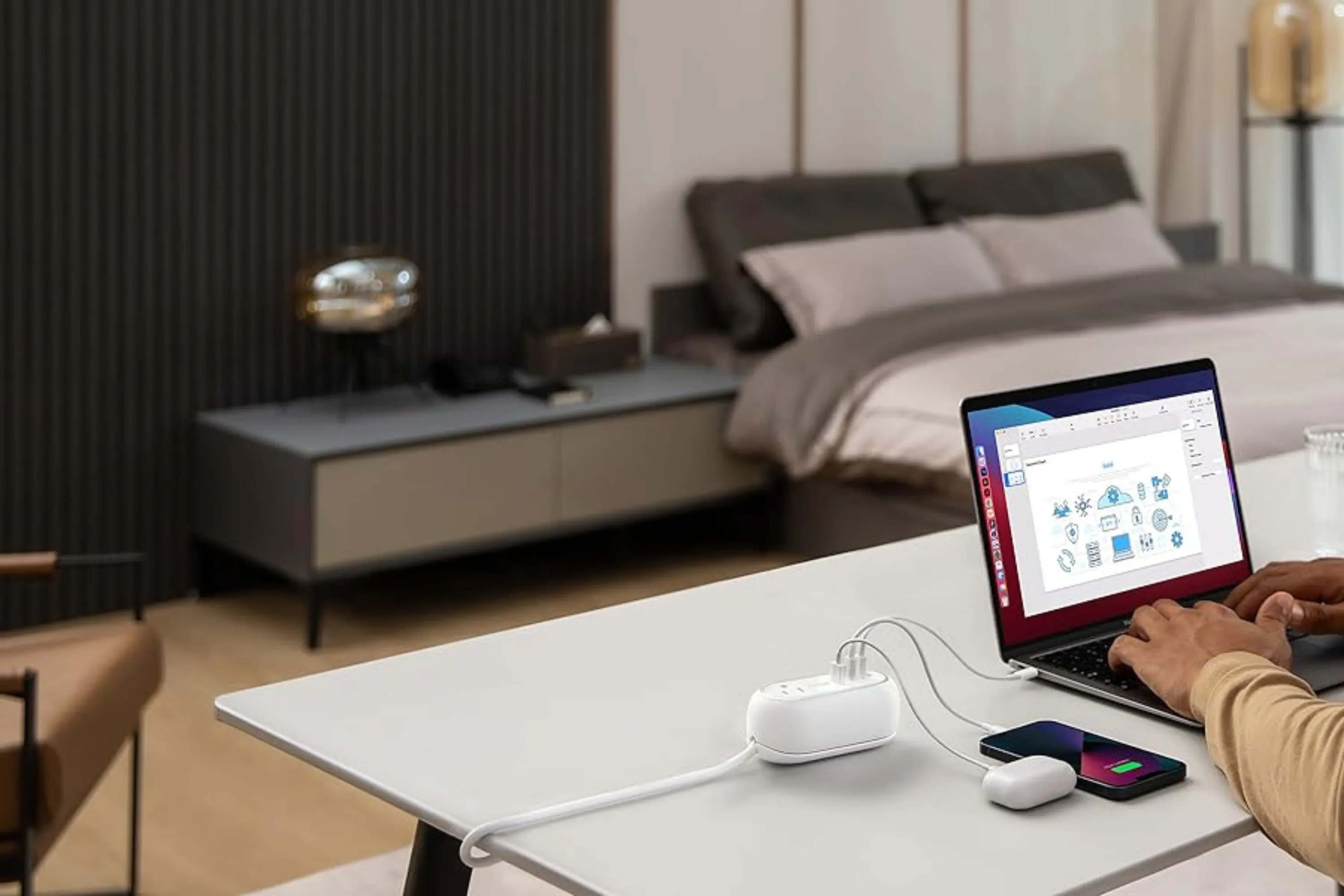 Trạm sạc Anker 615 GaNPrime Power Strip đang được sử dụng trên bàn làm việc, các thiết bị như laptop, điện thoại được cắm sạc qua cổng USB và ổ cắm AC, minh họa khả năng sạc đa năng.